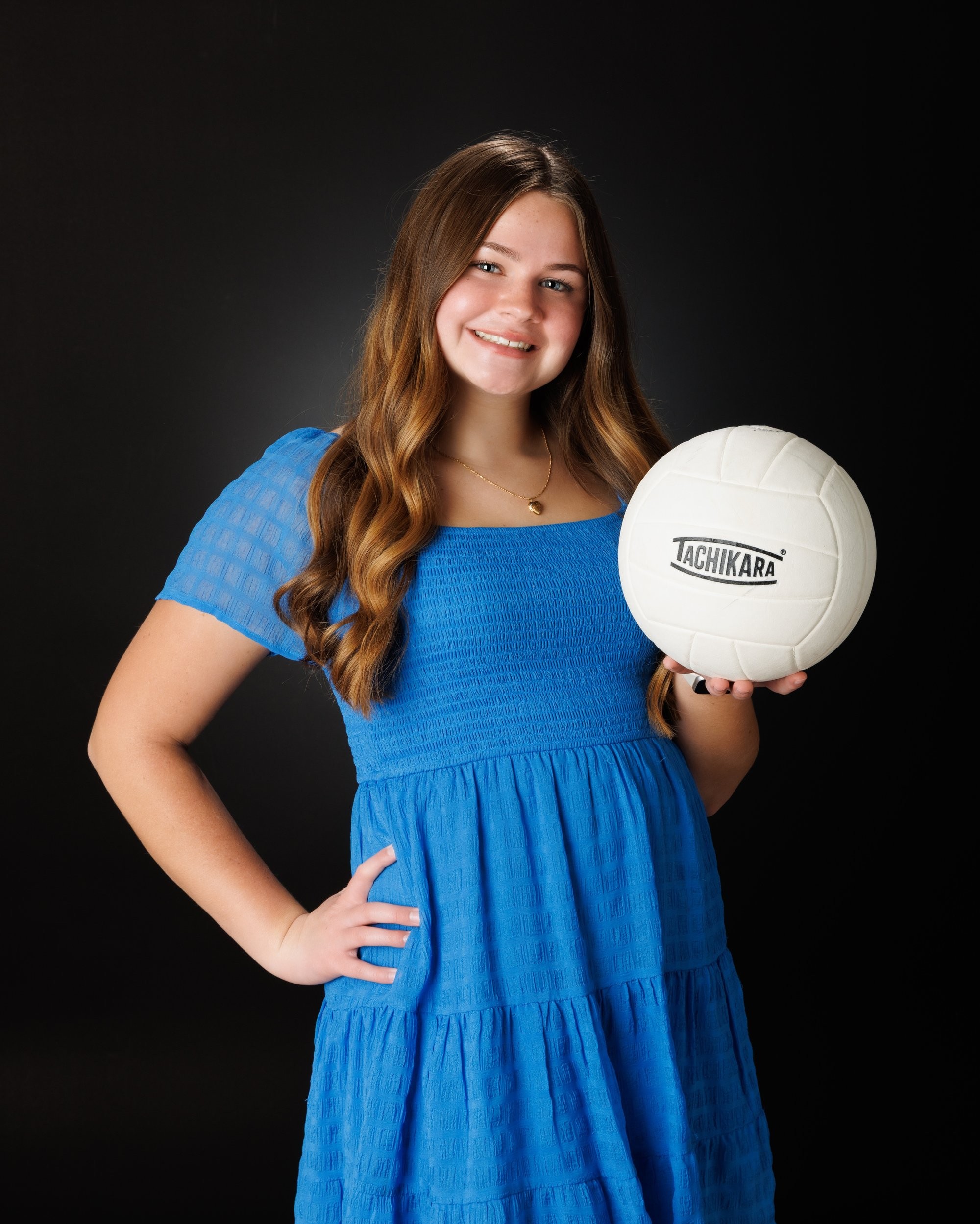 Natalie in blue dress and varsity jacket for Cabrini Senior Session photo shoot