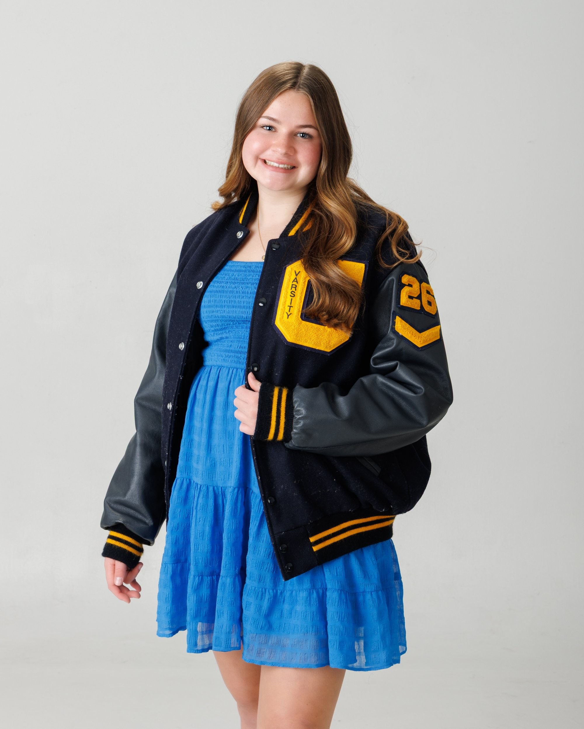 Natalie in blue dress and varsity jacket for Cabrini Senior Session photo shoot