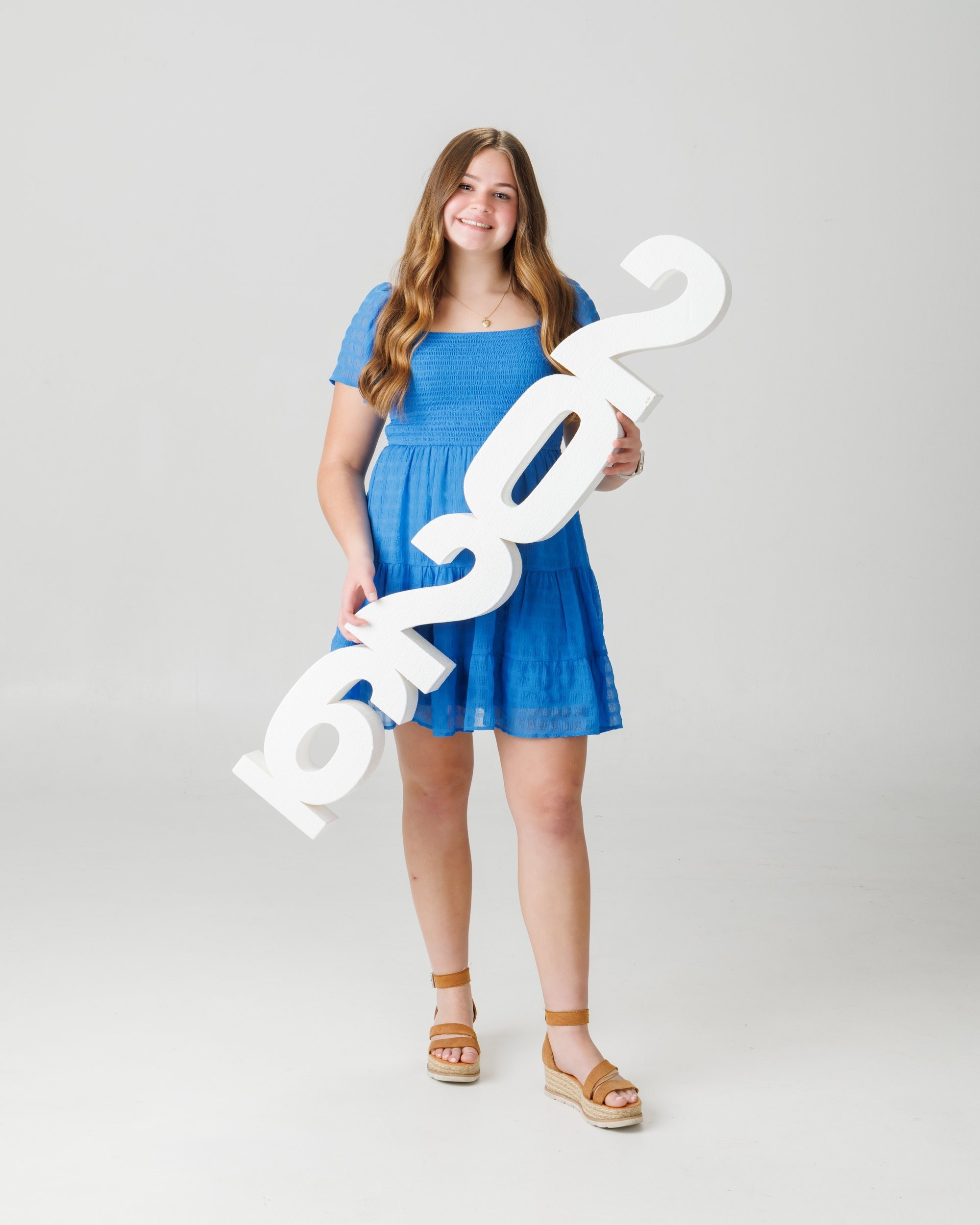 Natalie in blue dress and varsity jacket for Cabrini Senior Session photo shoot