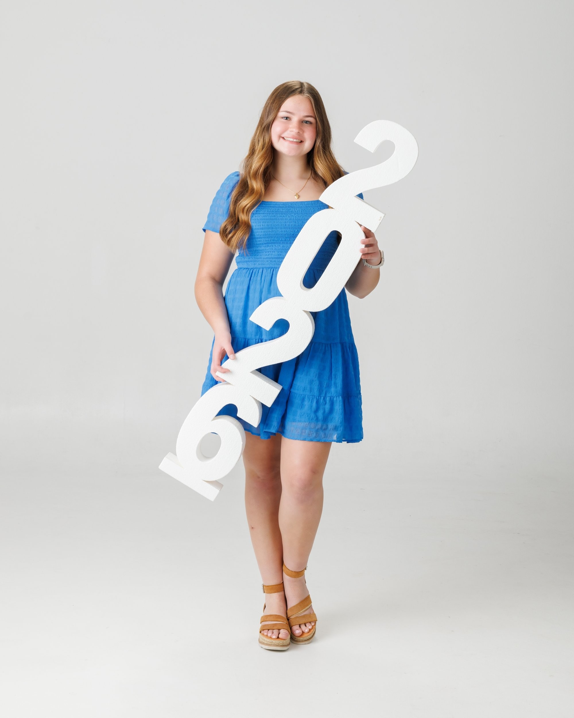Natalie in blue dress and varsity jacket for Cabrini Senior Session photo shoot