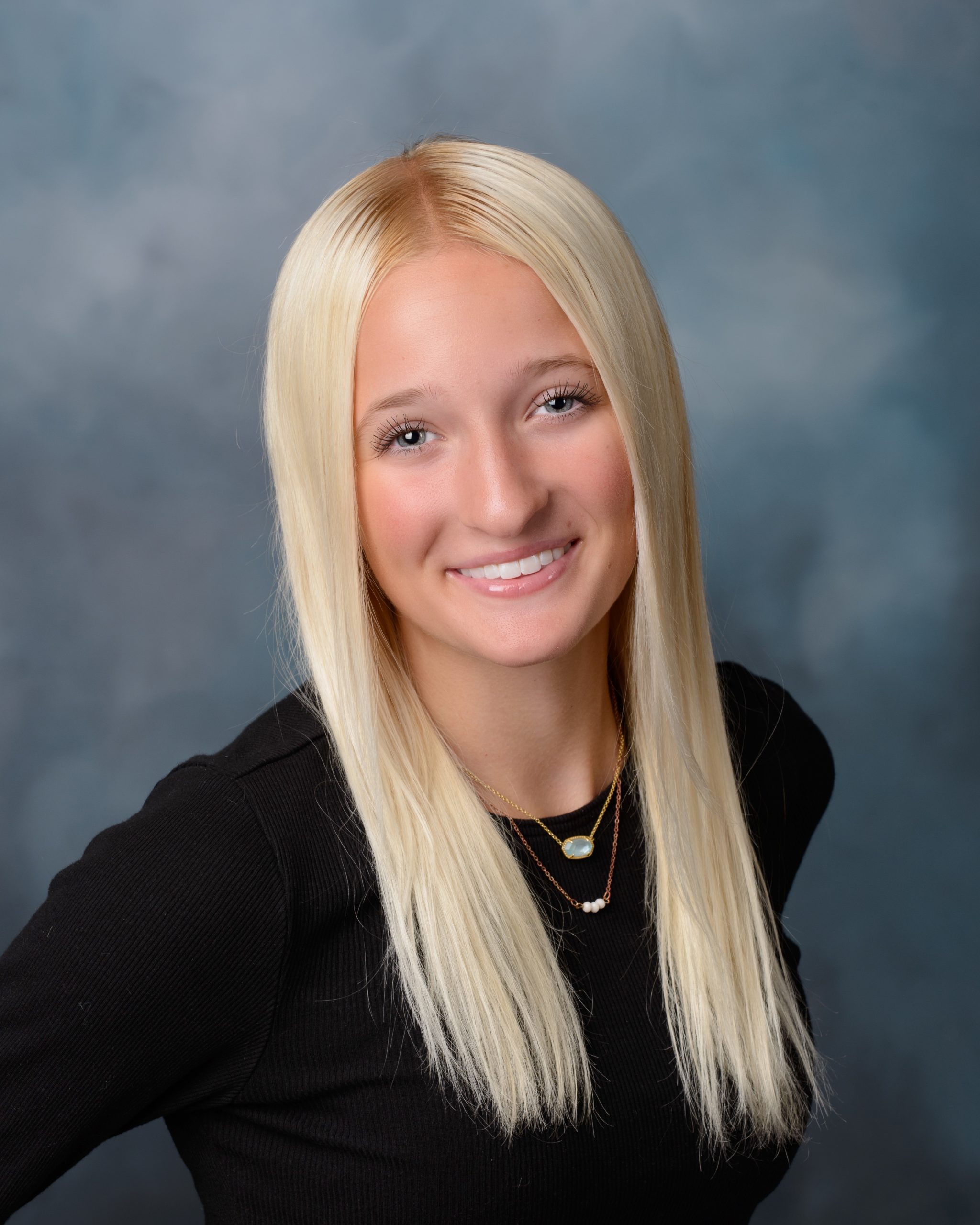 Female student in soft pink sweater with long hair for Cabrini senior yearbook photo