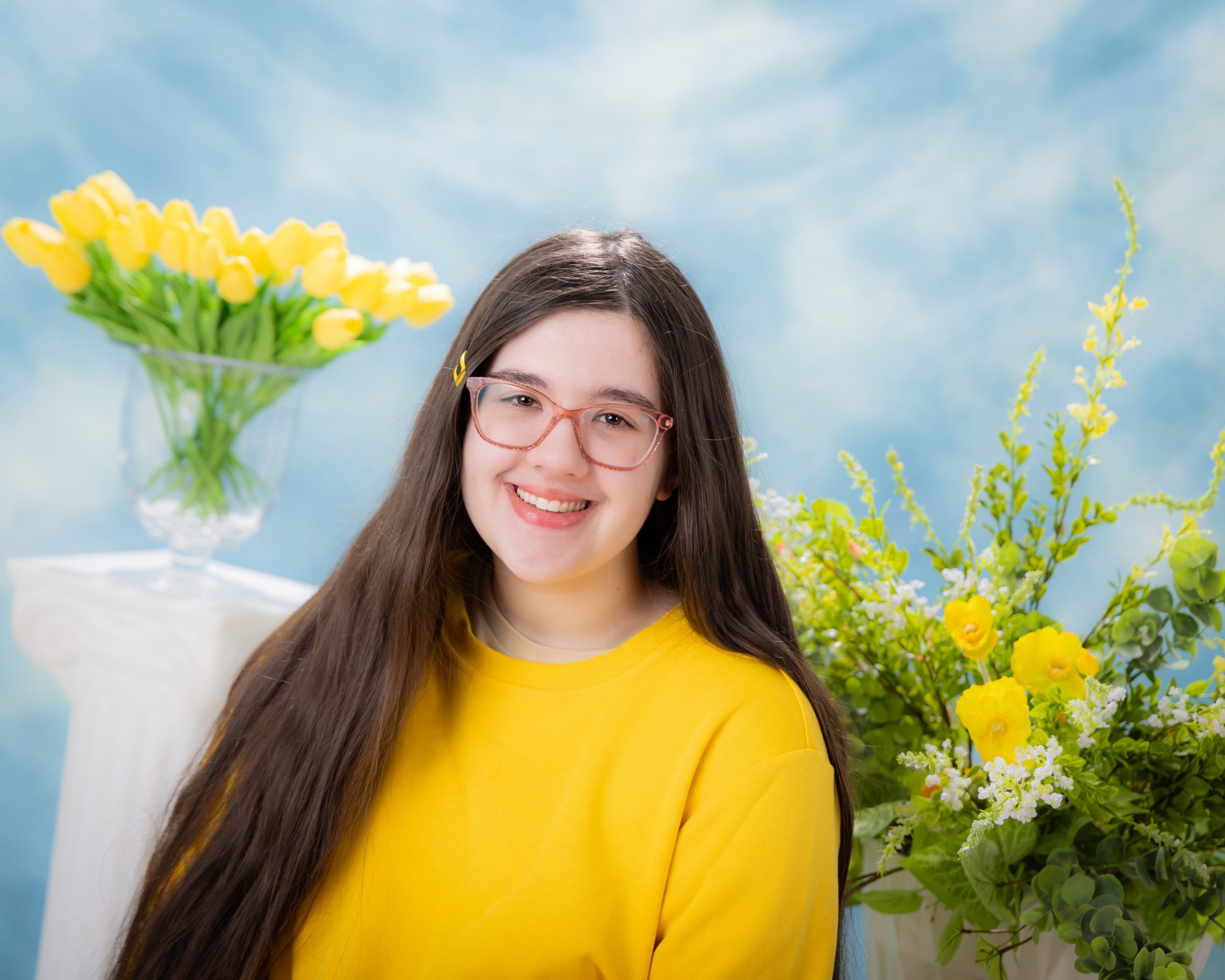 Anna lying on grass surrounded by yellow flowers, senior photography session