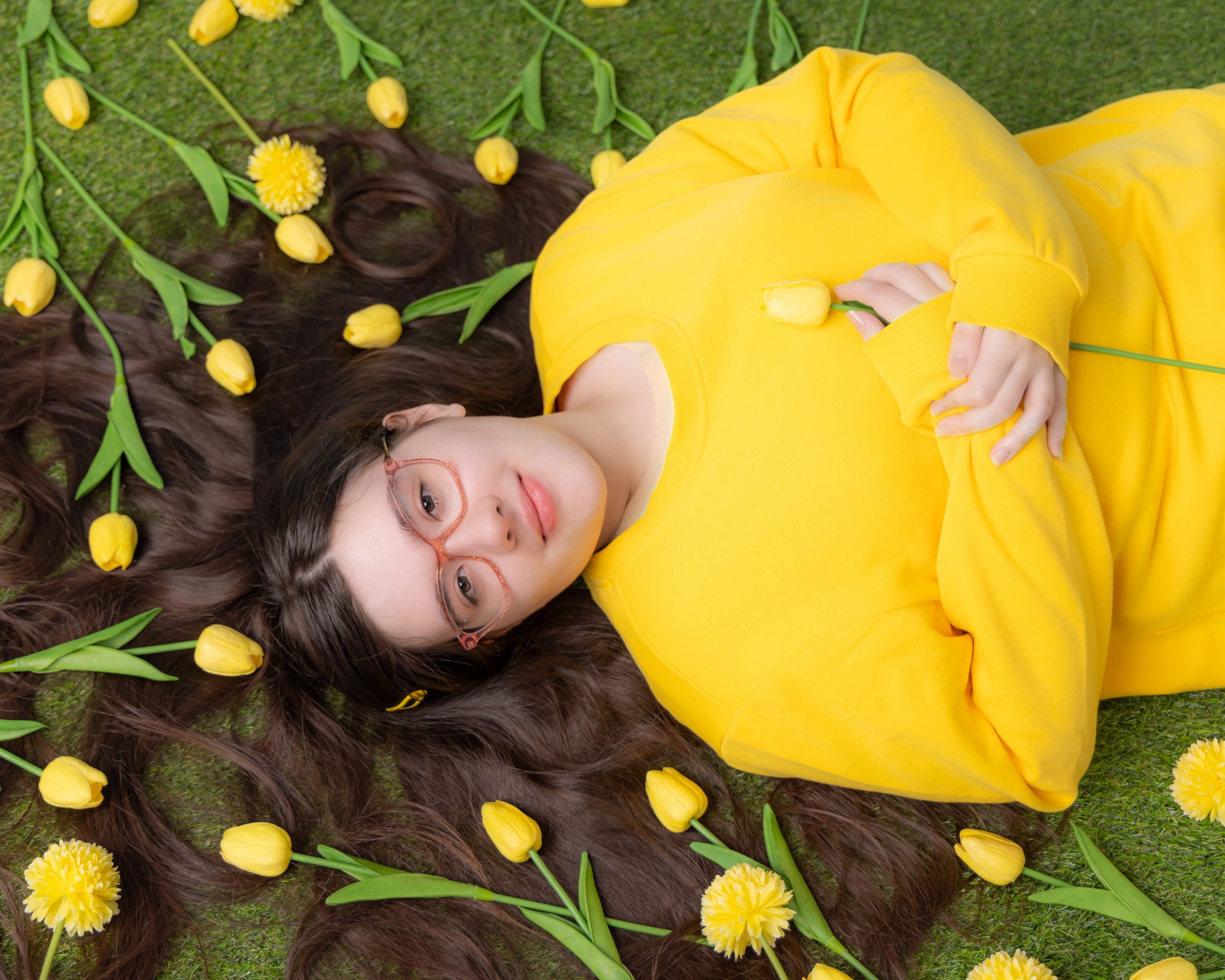 Anna resting on greenery with floral arrangements, Downriver senior photo shoot
