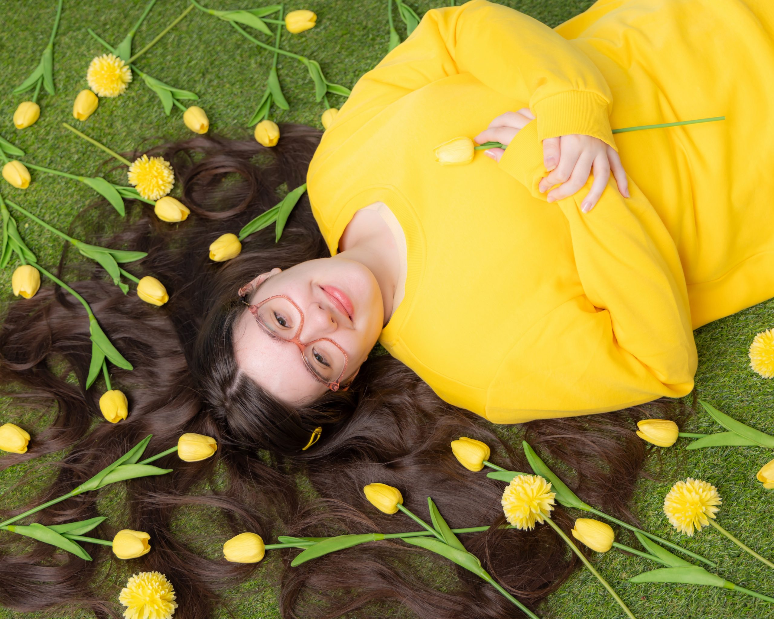 Anna resting on greenery with floral arrangements, Downriver senior photo shoot