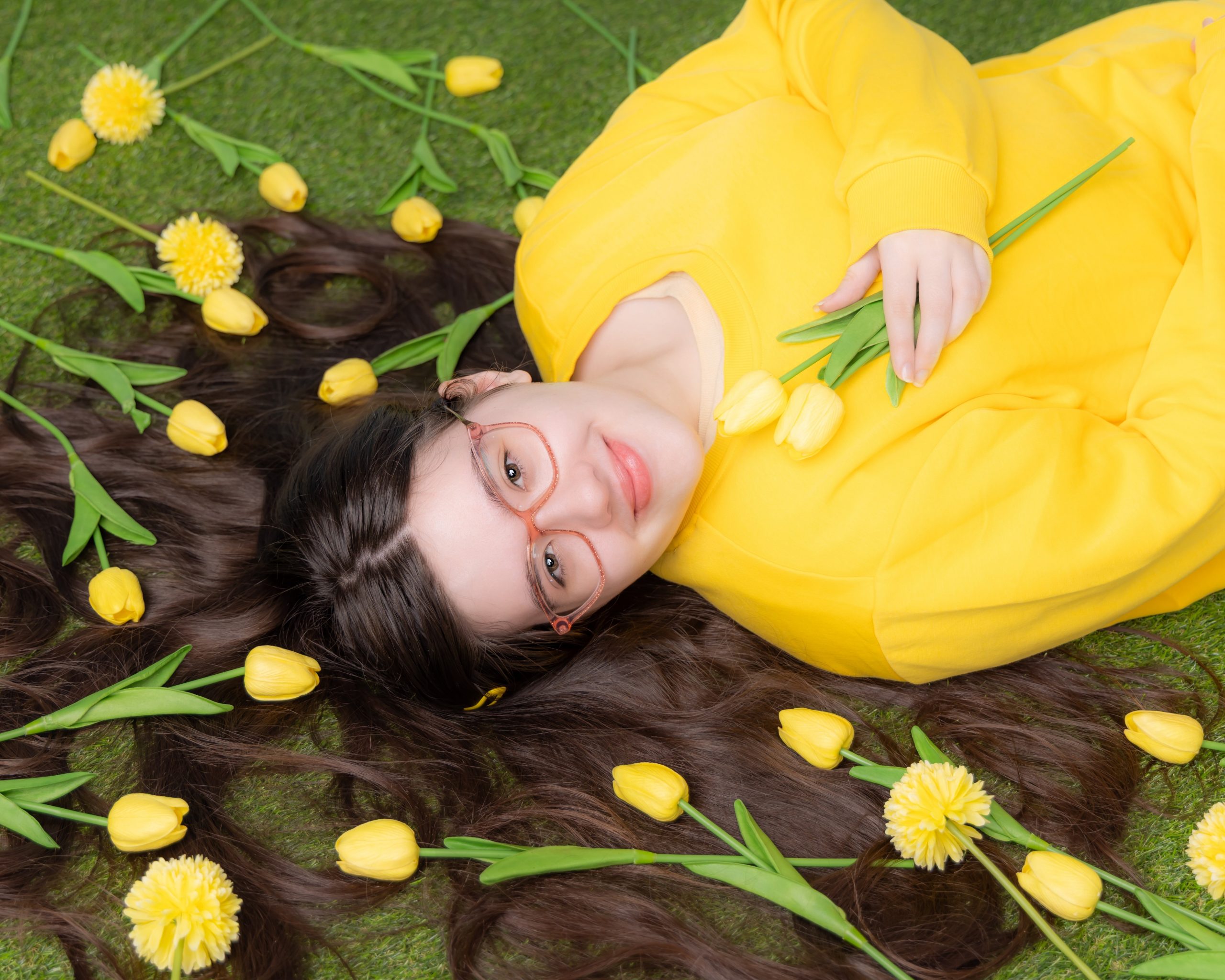 Anna resting on greenery with floral arrangements, Downriver senior photo shoot