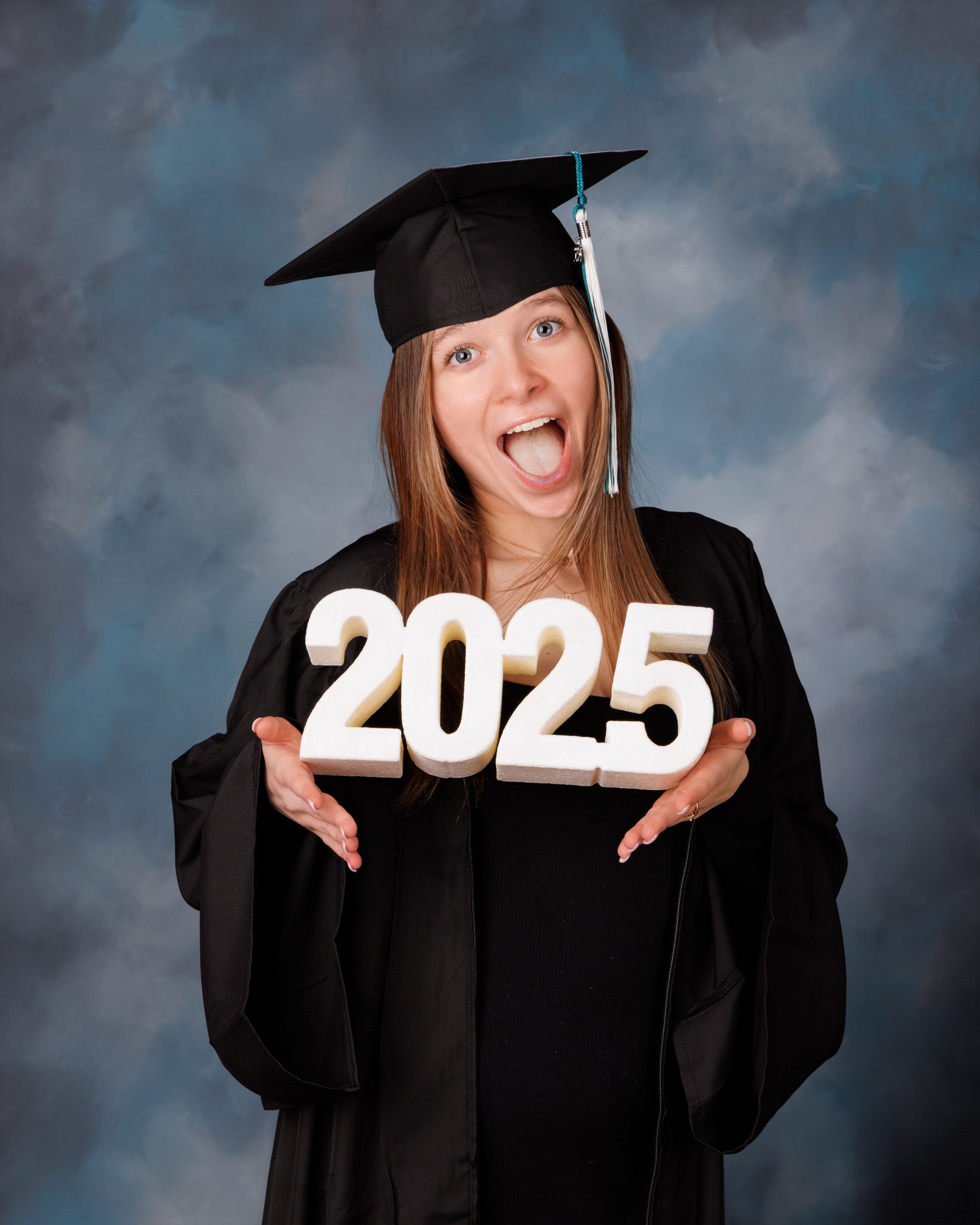 Hailey posing with graduation cap in floral dress during Downriver senior photo shoot