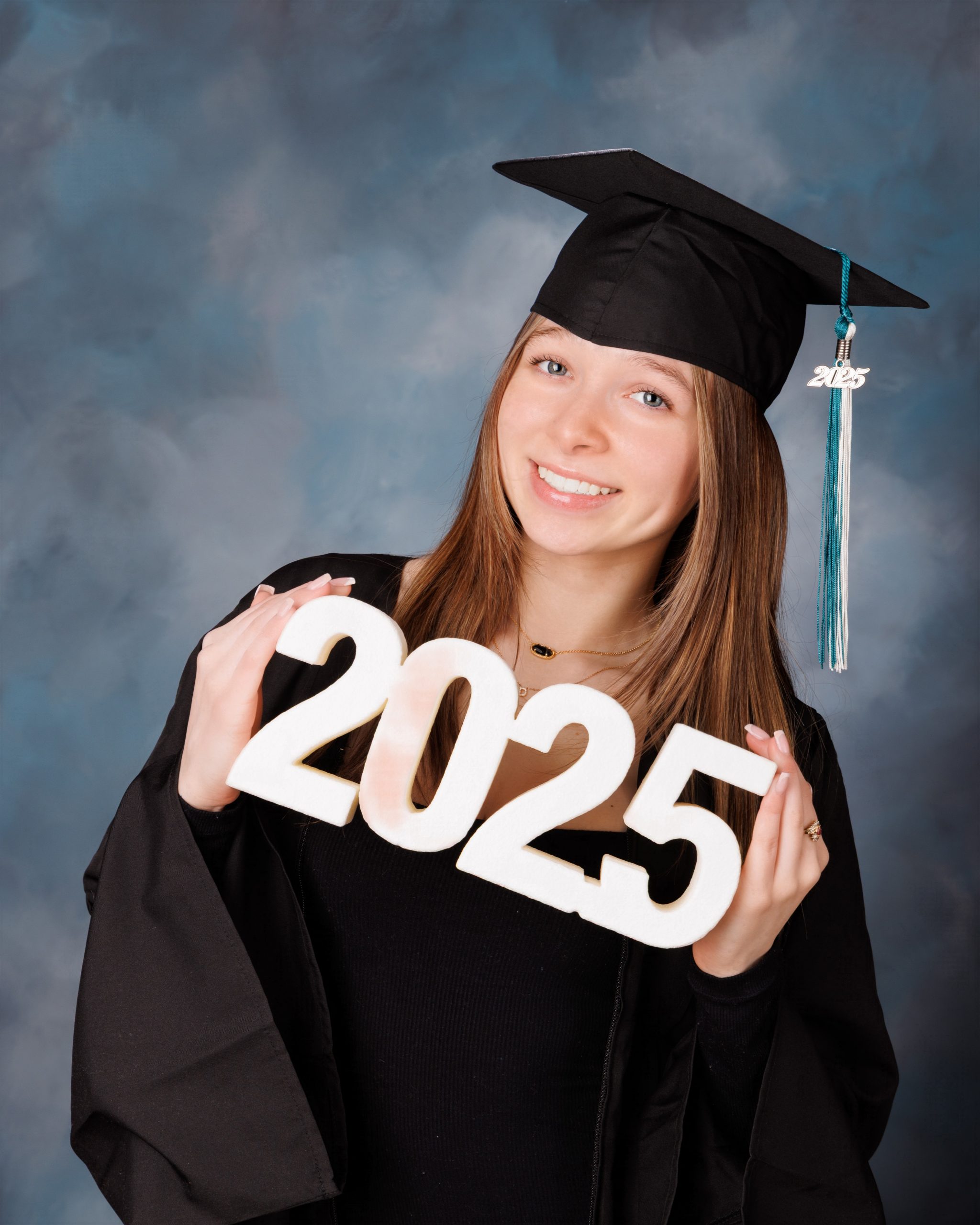 Hailey posing with graduation cap in floral dress during Downriver senior photo shoot