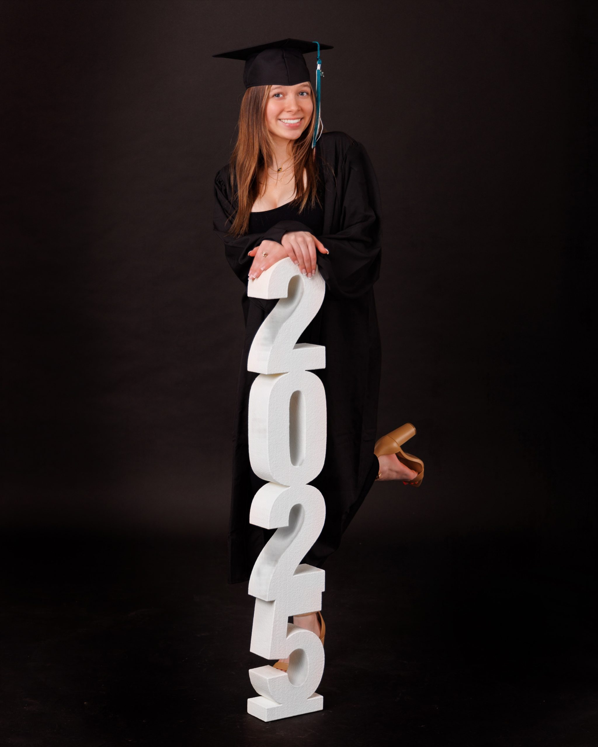 Hailey posing with graduation cap in floral dress during Downriver senior photo shoot