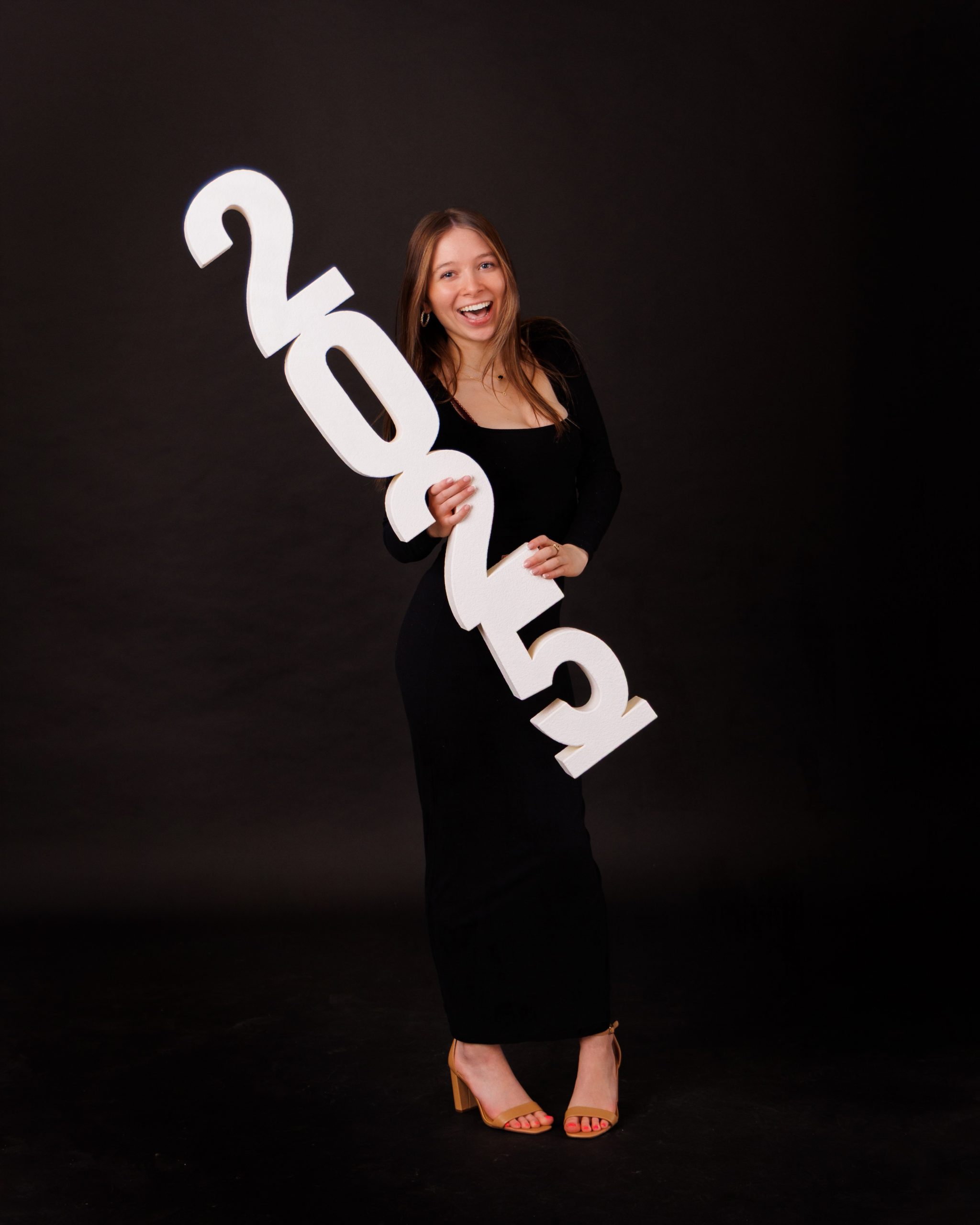 Hailey posing with graduation cap in floral dress during Downriver senior photo shoot