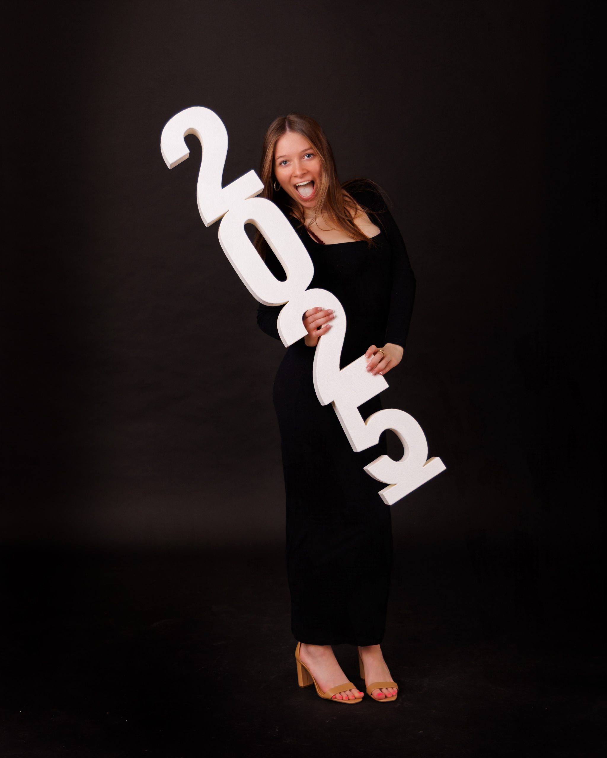 Hailey posing with graduation cap in floral dress during Downriver senior photo shoot