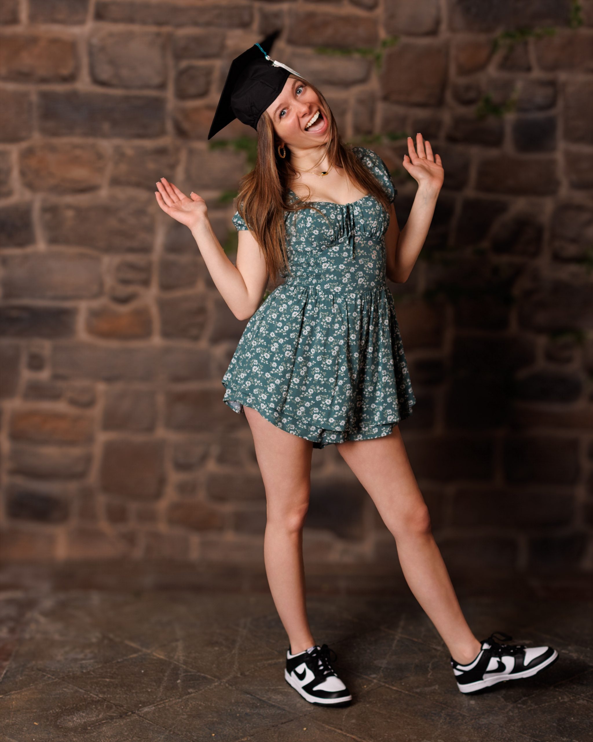 Hailey posing with graduation cap in floral dress during Downriver senior photo shoot