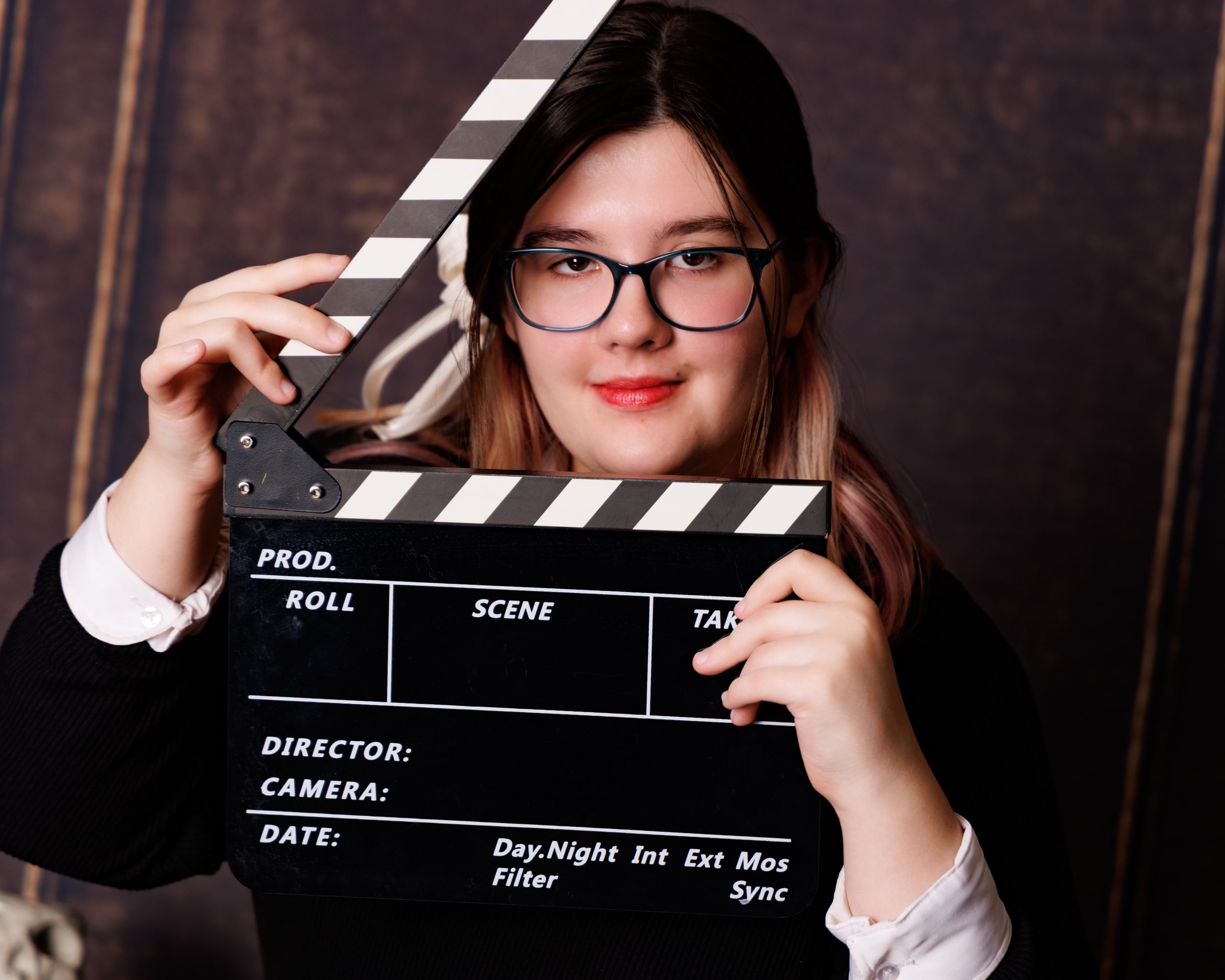 Kaitlyn posing with horror-themed props including a knife and book in a studio setup for her Canton Plymouth senior session
