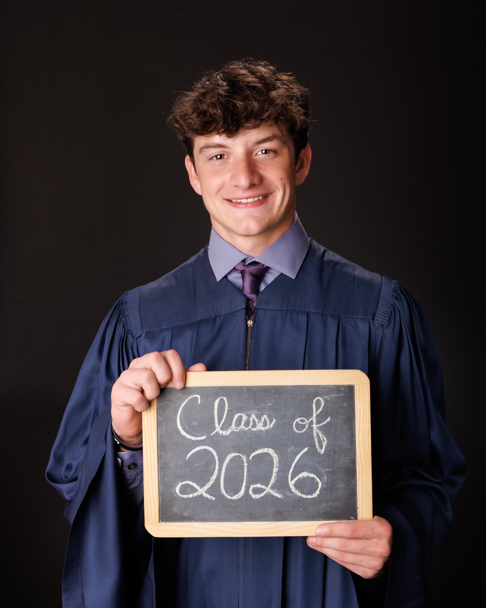 Catholic High School senior Edward holding football in professional studio photograph
