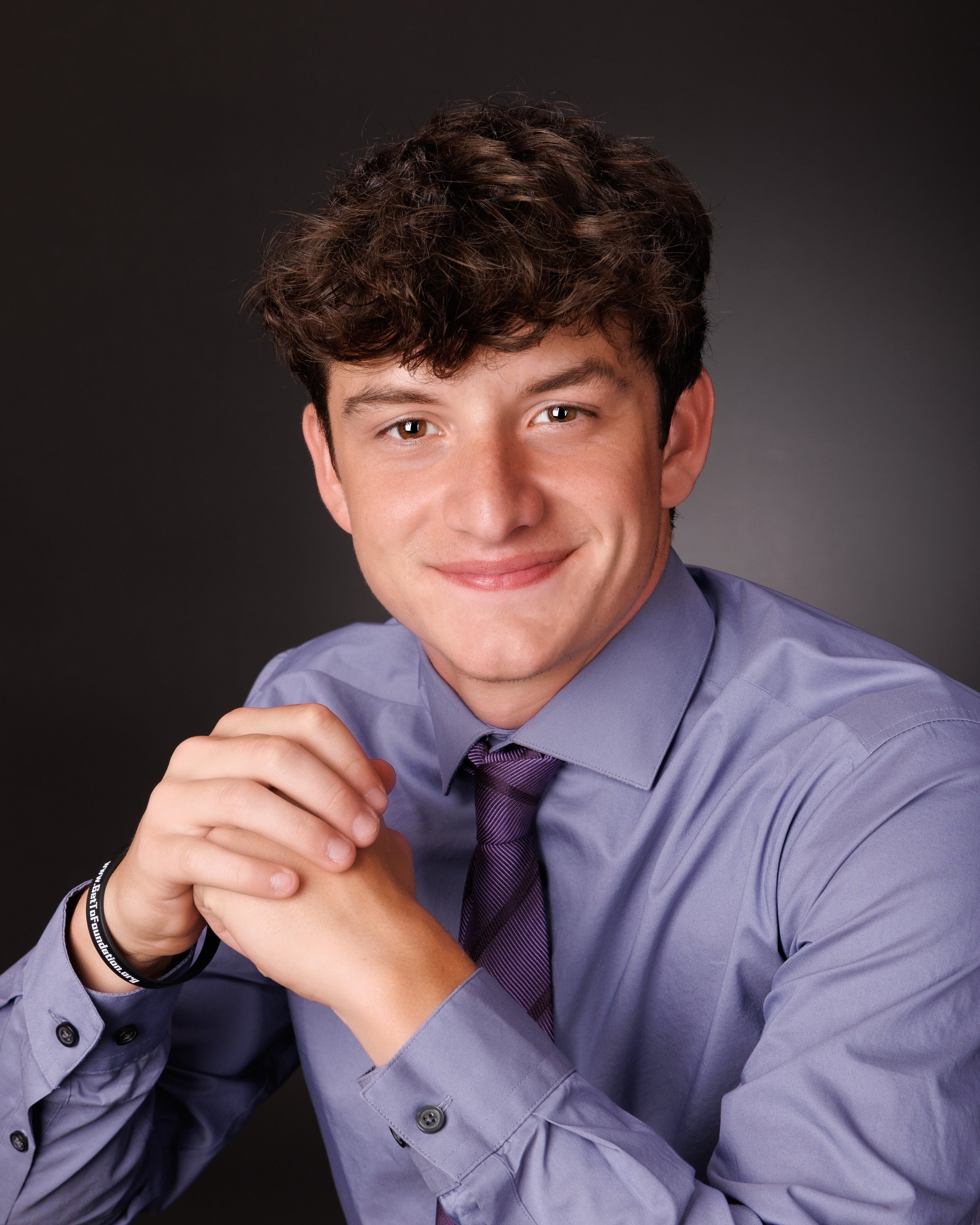 Catholic High School senior Edward with clasped hands in studio senior photography session