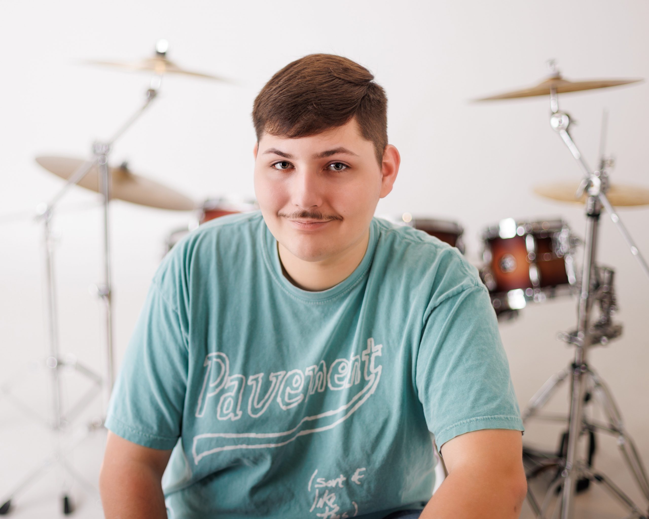 Tobias drumming professionally in formal attire during Dearborn senior photography session