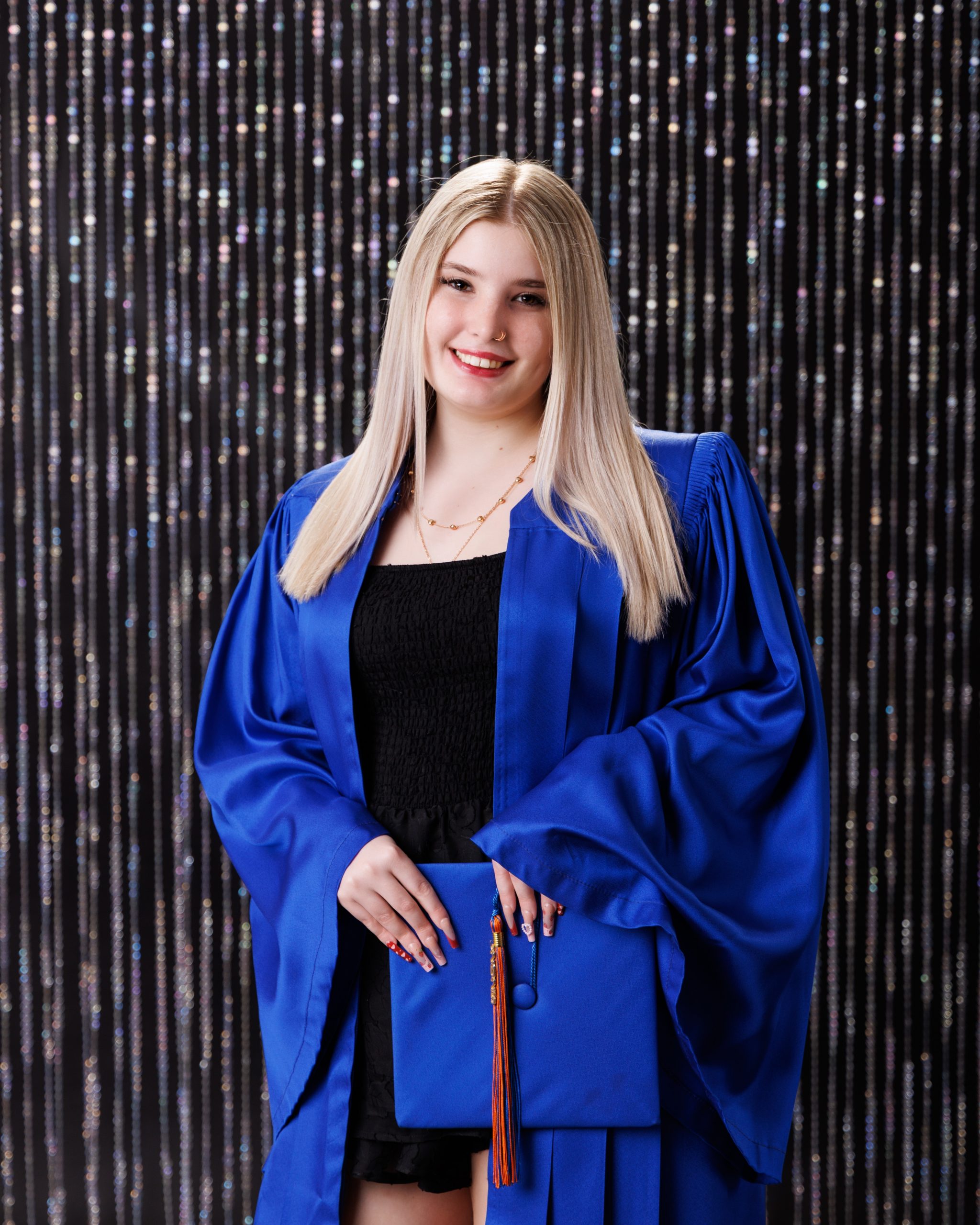 Graduation portrait of Dearborn senior Alysha in blue gown holding diploma