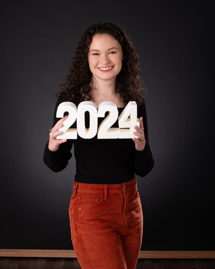 Senior student holding '2024' numbers during Downriver photo session