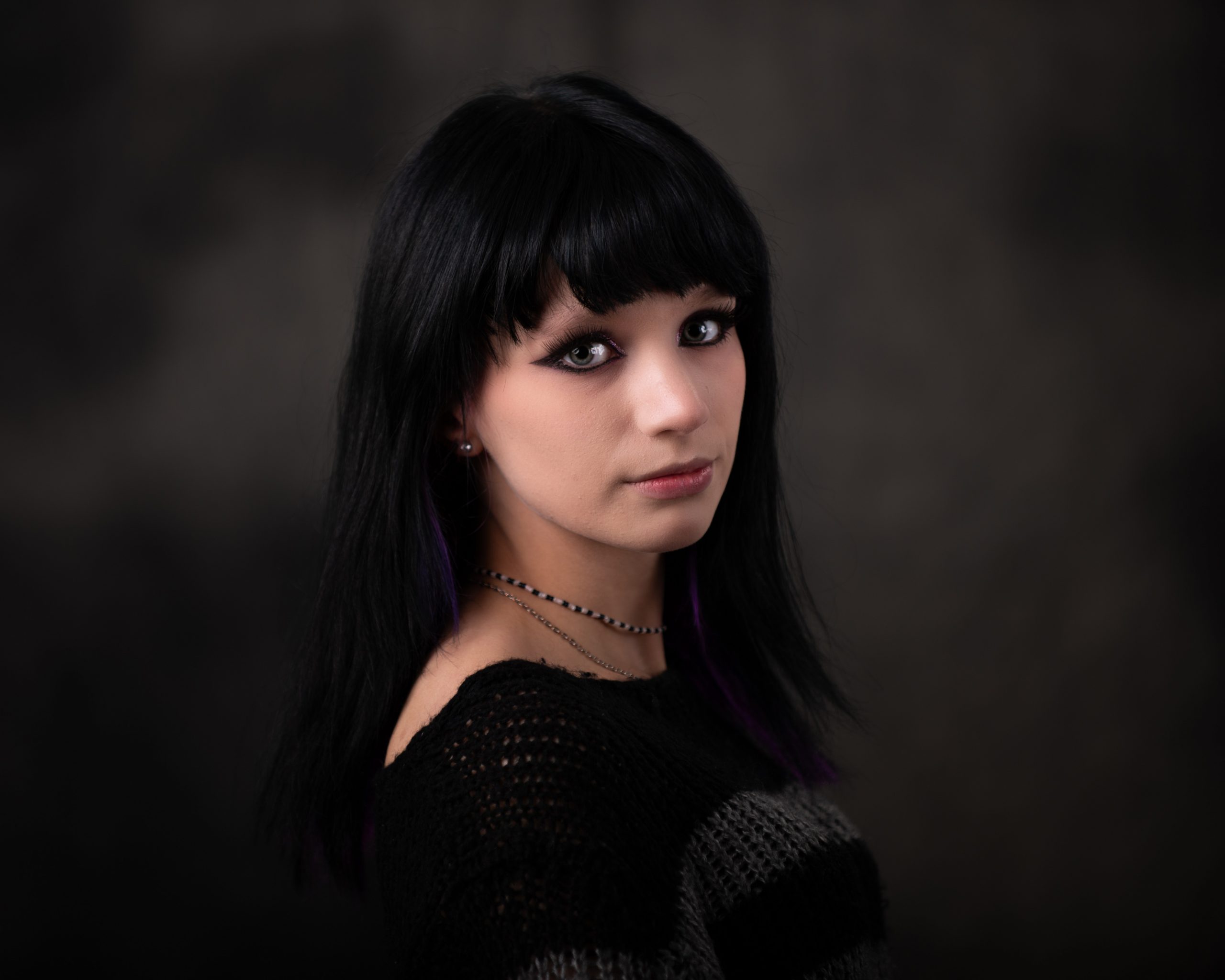 Close-up of Ashley's gothic makeup and black hair with purple highlights for Downriver senior photography