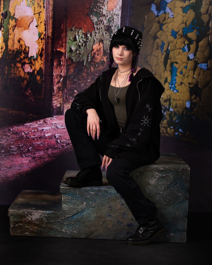 Ashley seated on stone steps with peeling paint backdrop for Downriver senior photography