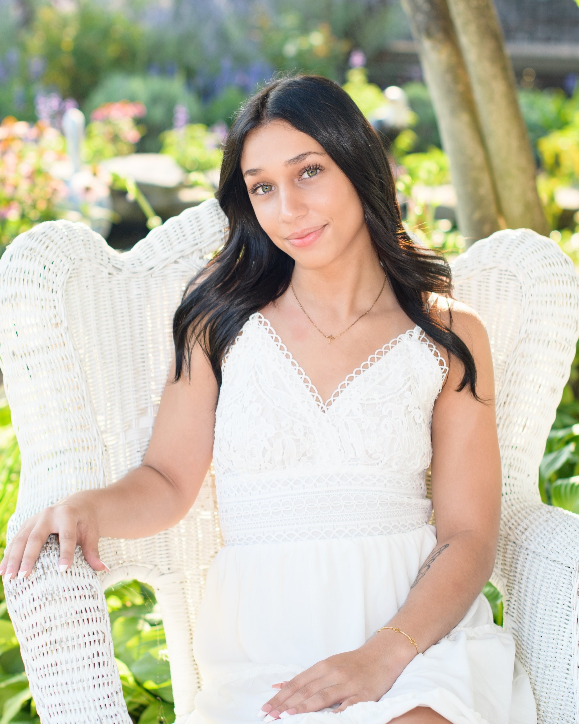 Natural light senior photography in a park setting, showcasing a young woman's casual style with a visible butterfly tattoo