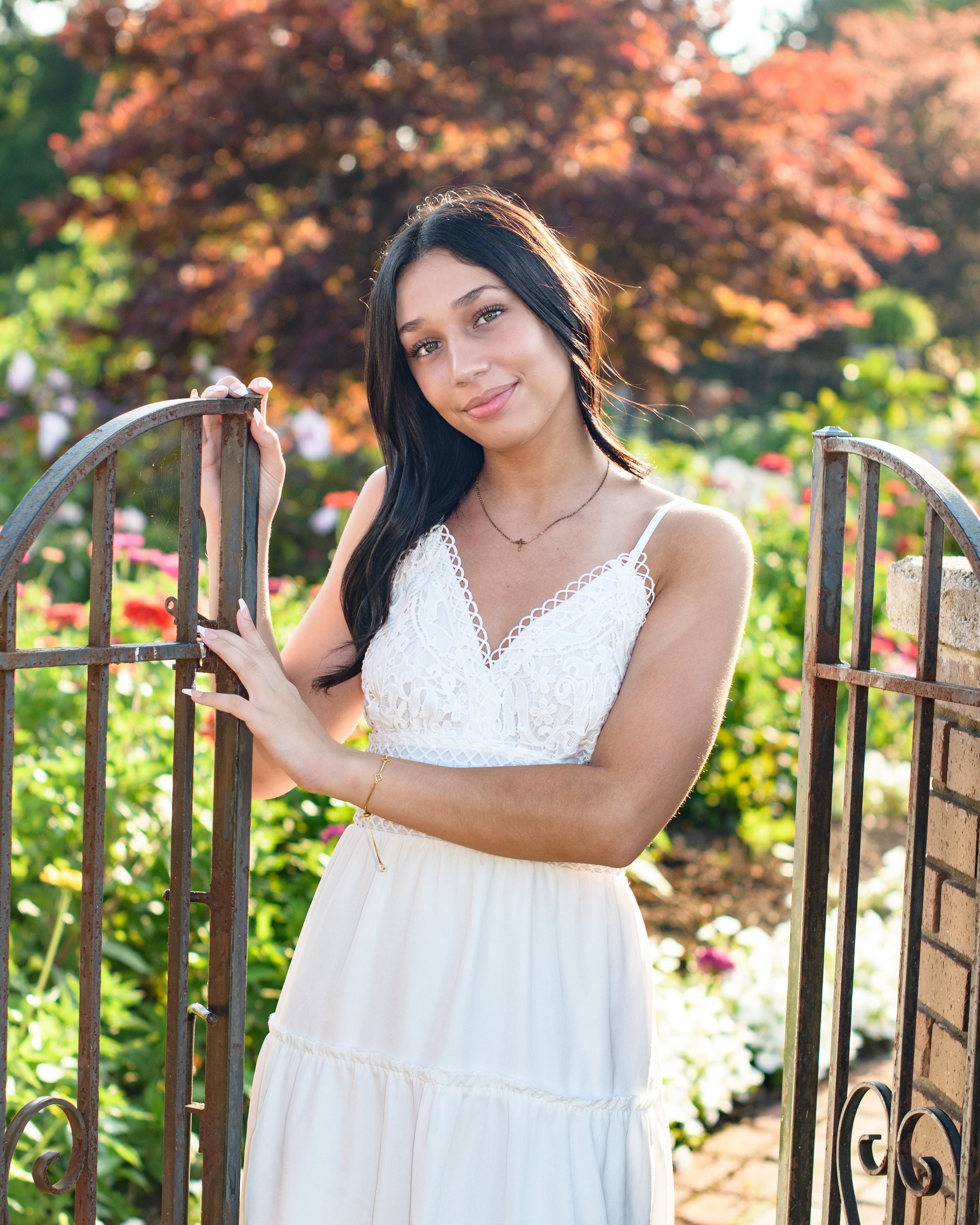 Natural light senior photography in a park setting, showcasing a young woman's casual style with a visible butterfly tattoo