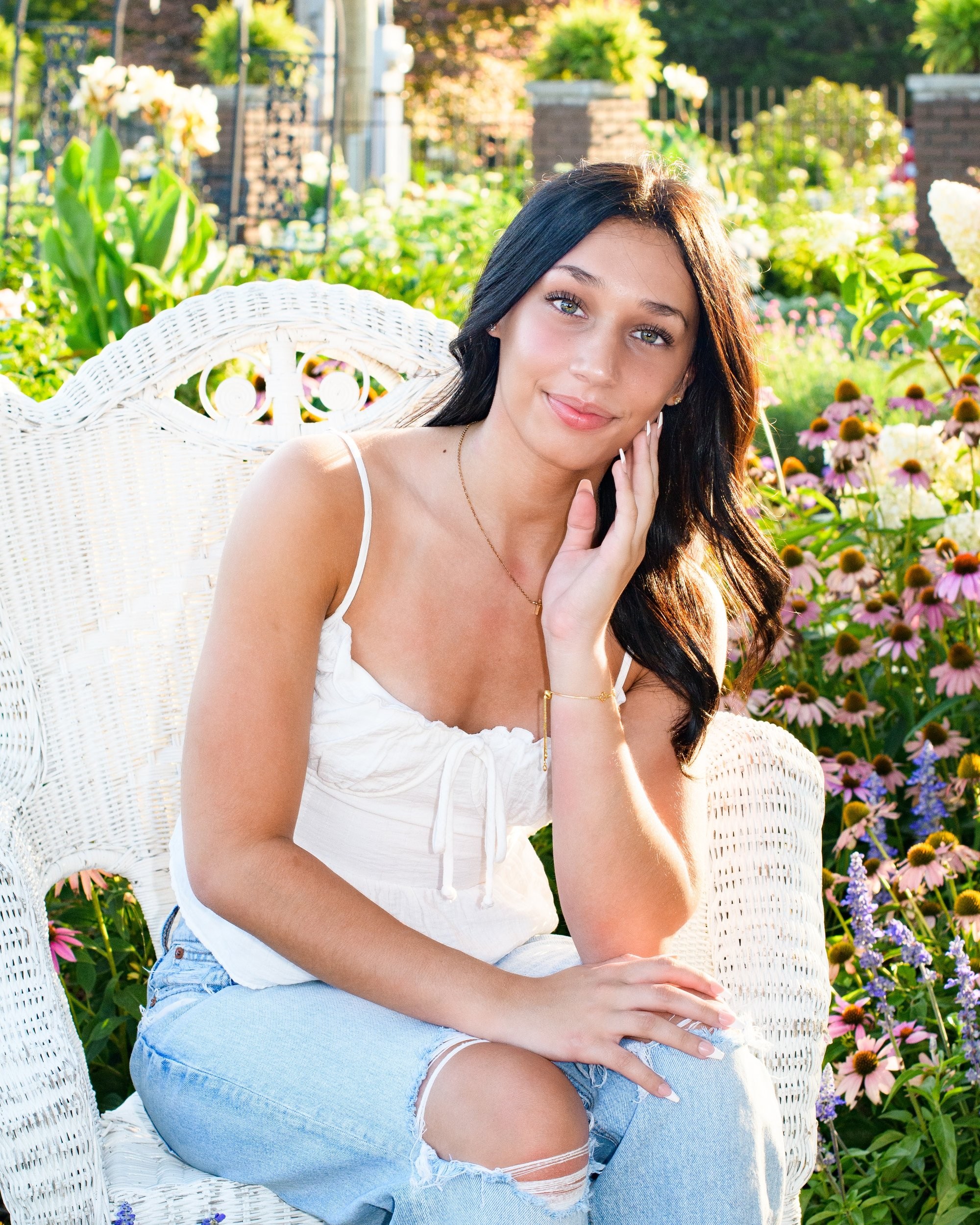 Natural light senior photography in a park setting, showcasing a young woman's casual style with a visible butterfly tattoo