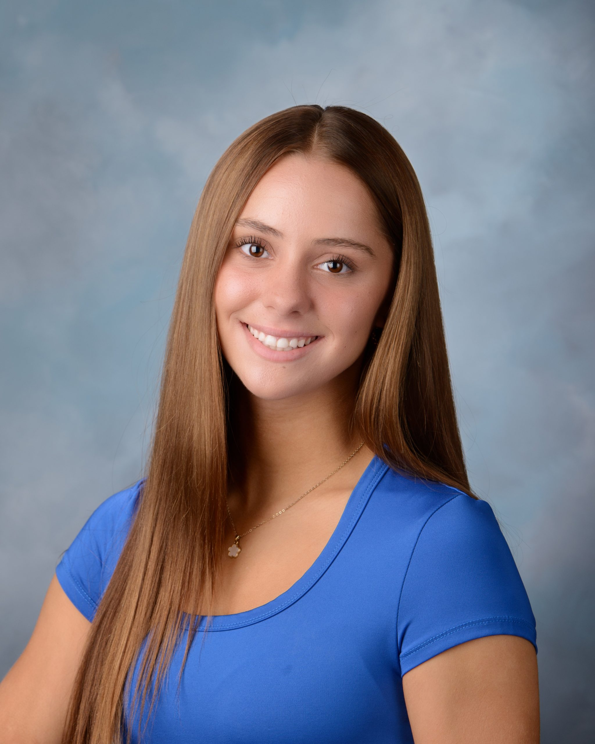 Senior headshot featuring braided hairstyle, black off-shoulder top, pearl necklace, and Downriver photography studio background