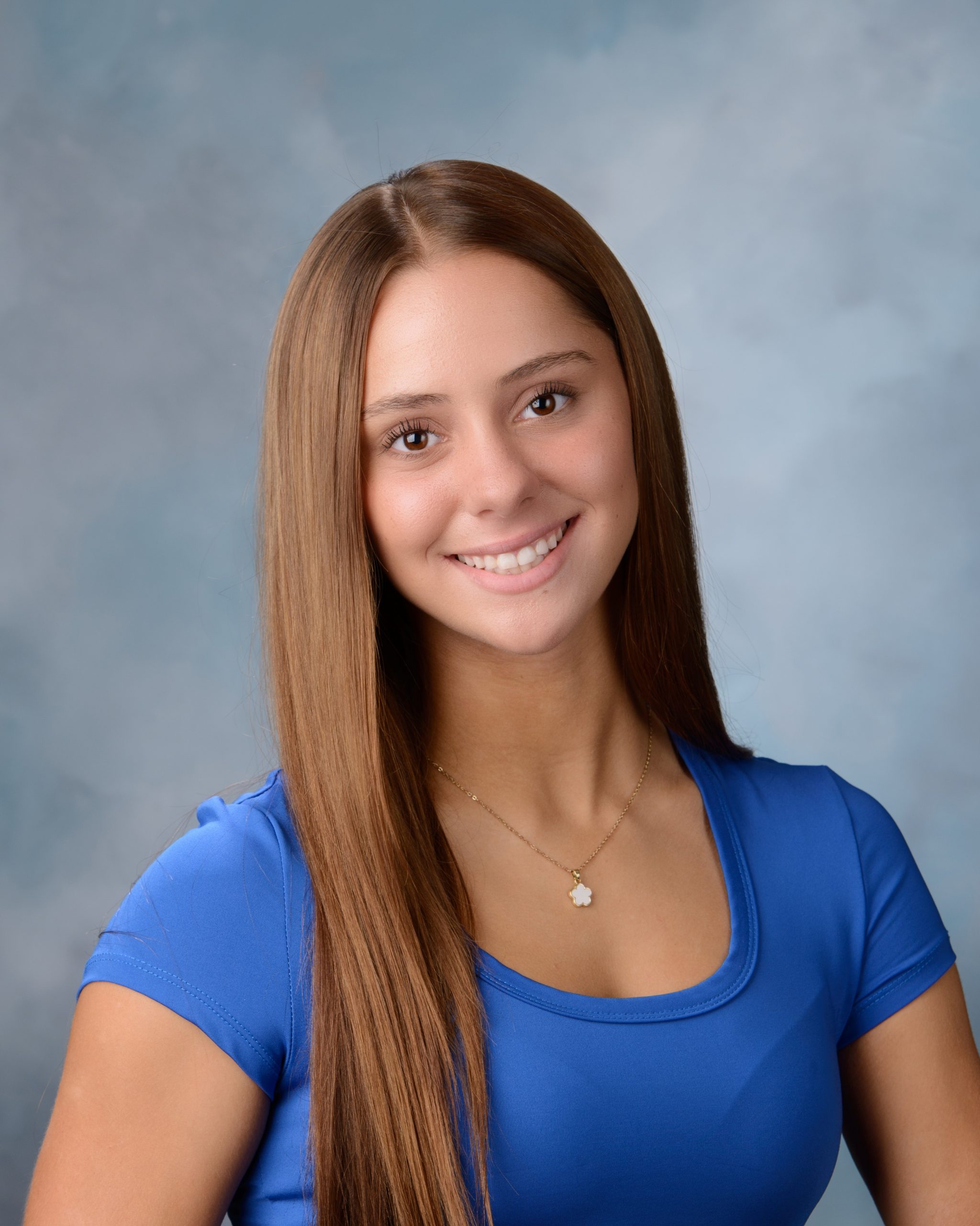 Senior headshot featuring braided hairstyle, black off-shoulder top, pearl necklace, and Downriver photography studio background