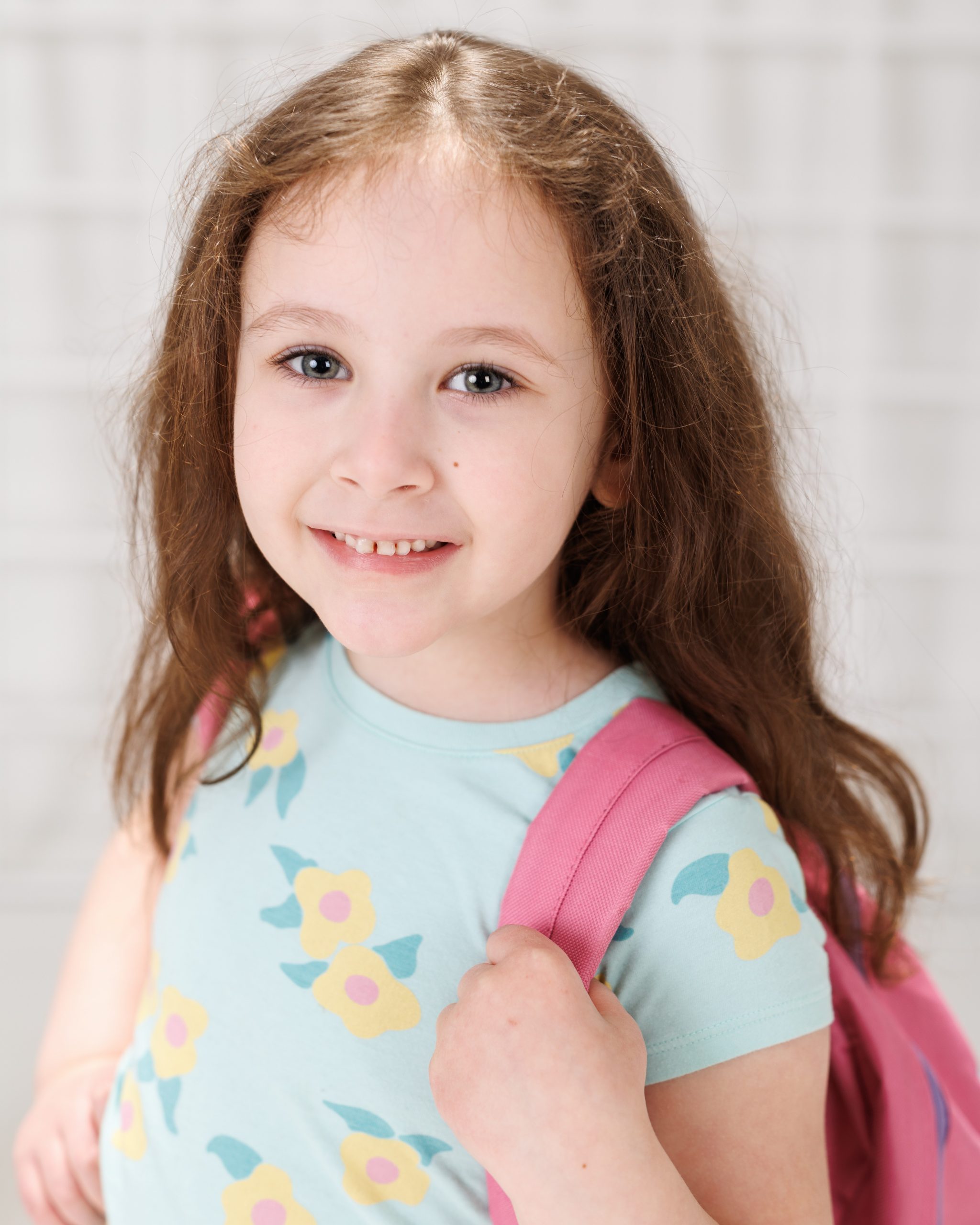 Young girl unlocking a blue school locker, wearing floral shirt and butterfly skirt
