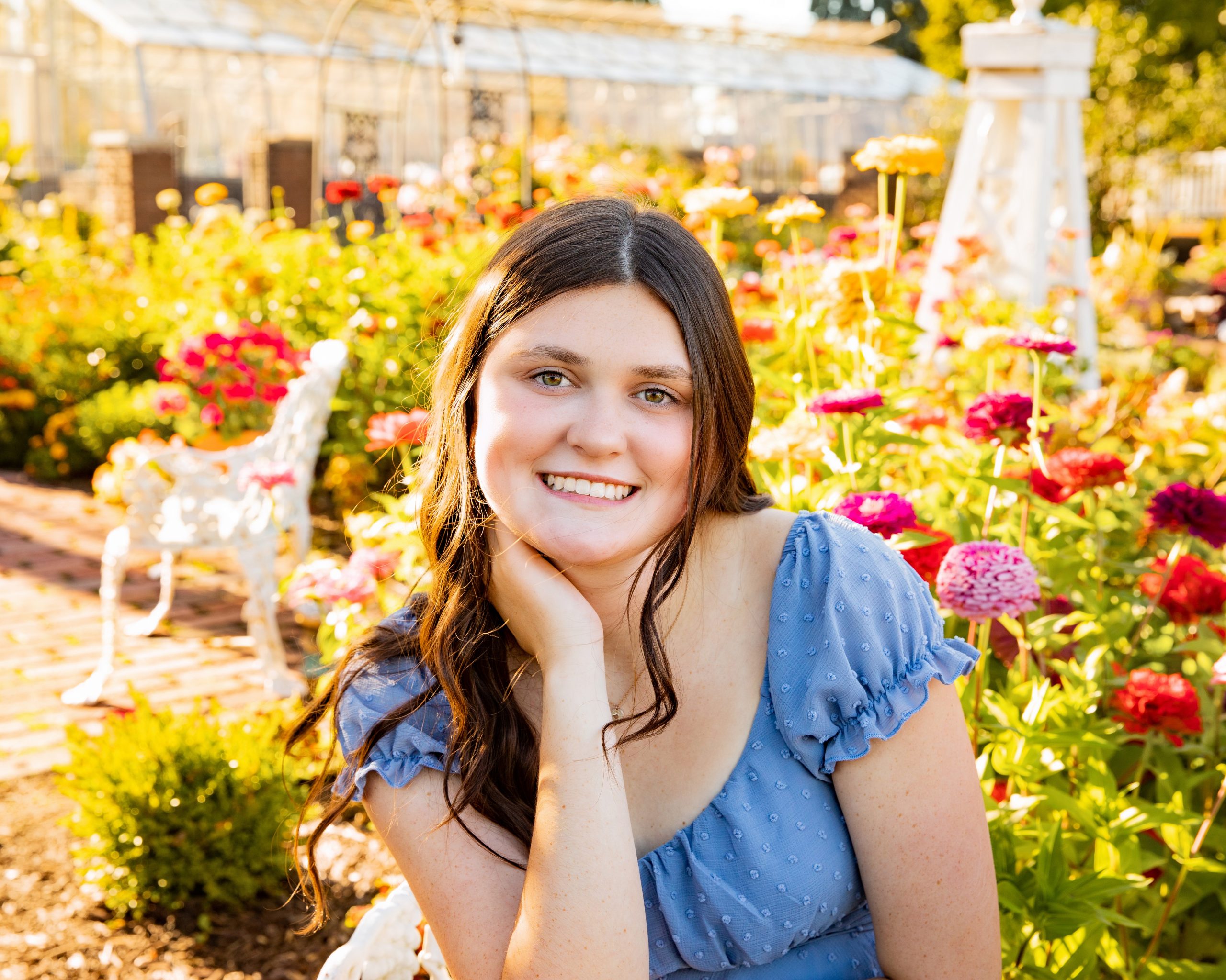 senior photography session featuring a young woman in blue dress and cowboy boots at Grosse Ile garden