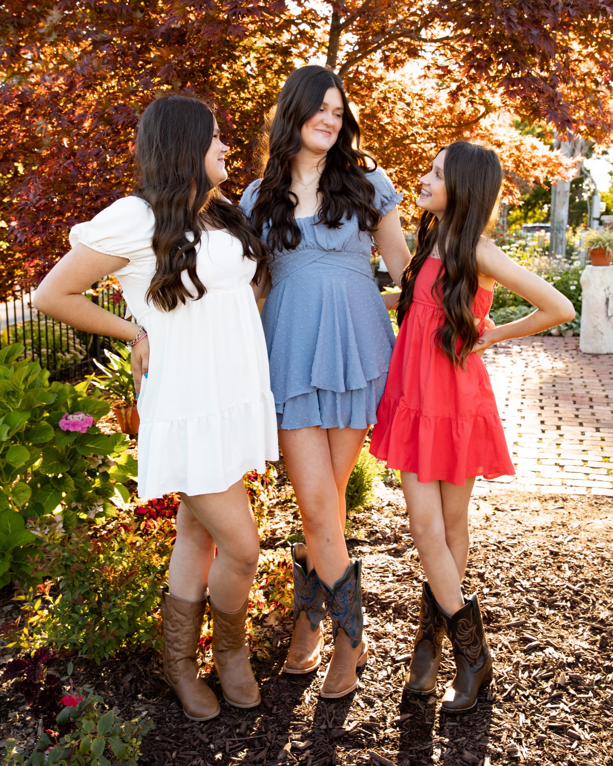 senior photography session featuring a young woman in blue dress and cowboy boots at Grosse Ile garden