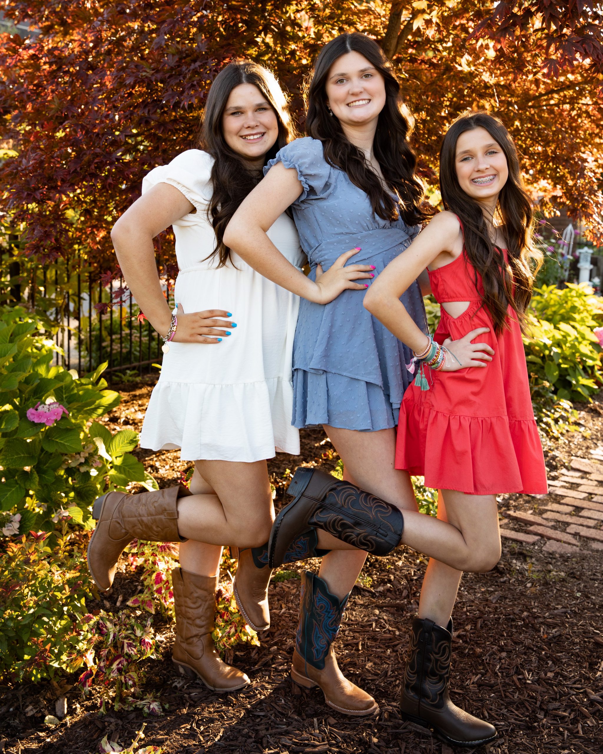 senior photography session featuring a young woman in blue dress and cowboy boots at Grosse Ile garden