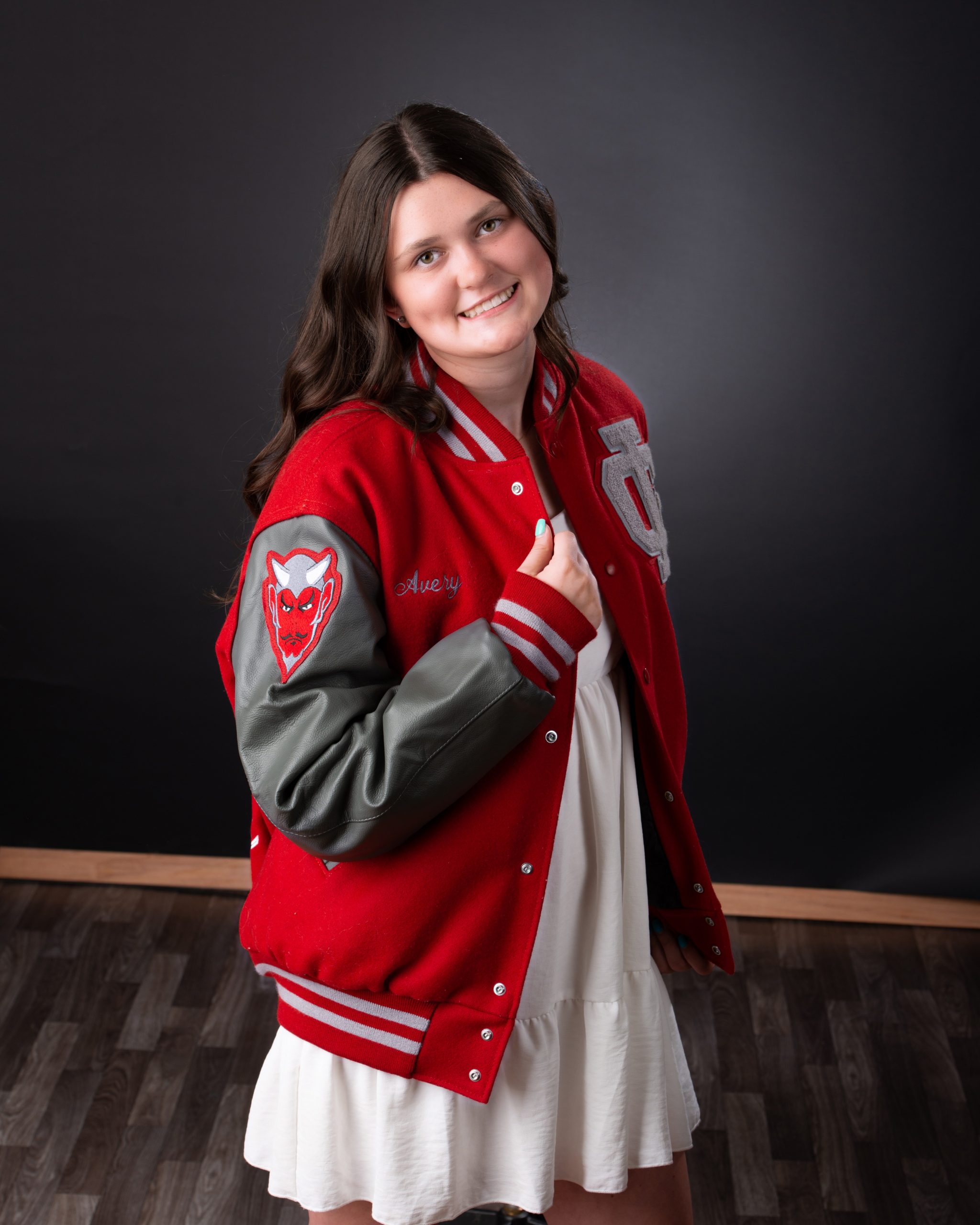 Grosse Ile senior photo session featuring student in red varsity jacket holding basketball