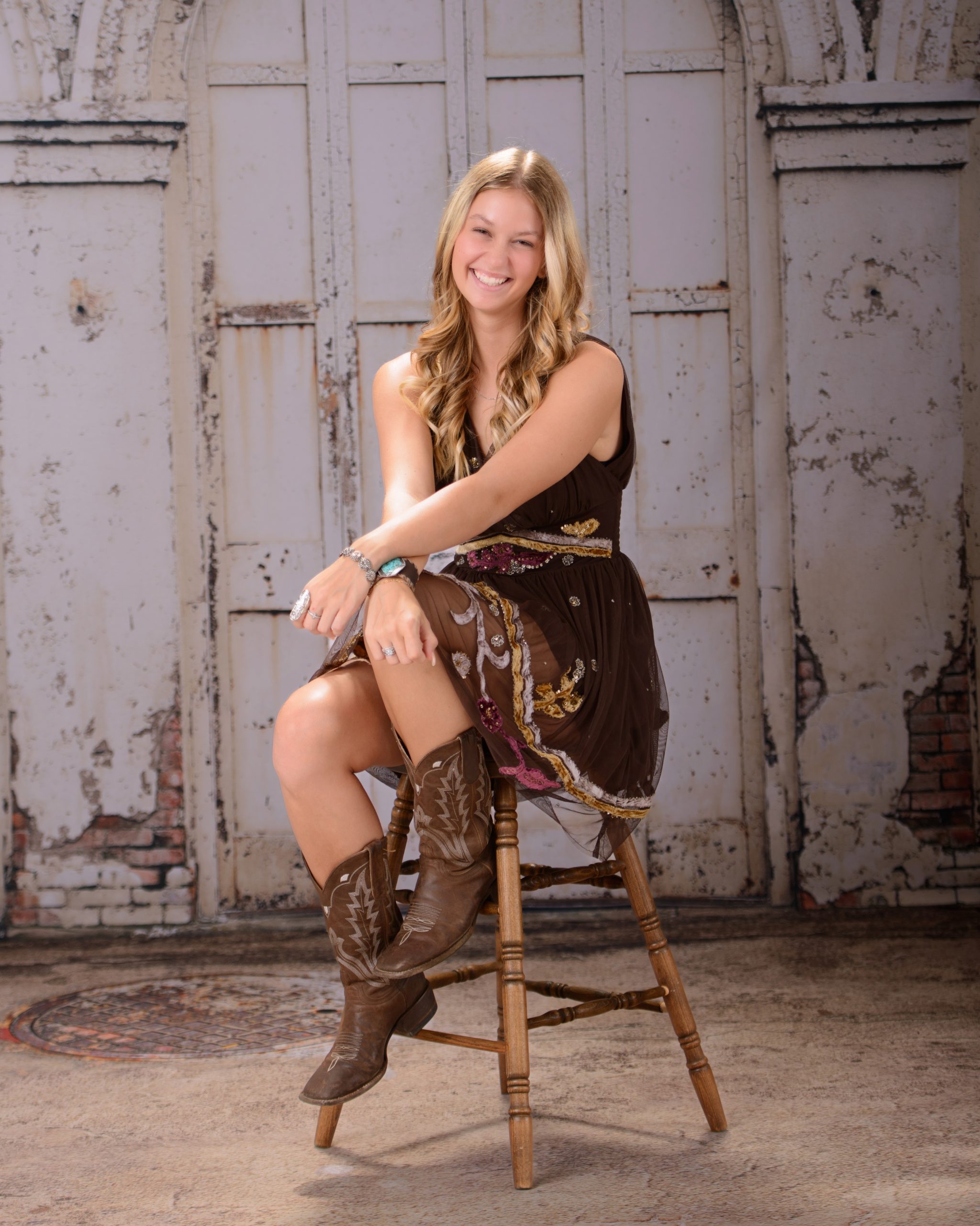 Kacey Allen Park senior portrait seated on wooden stool with confident smile