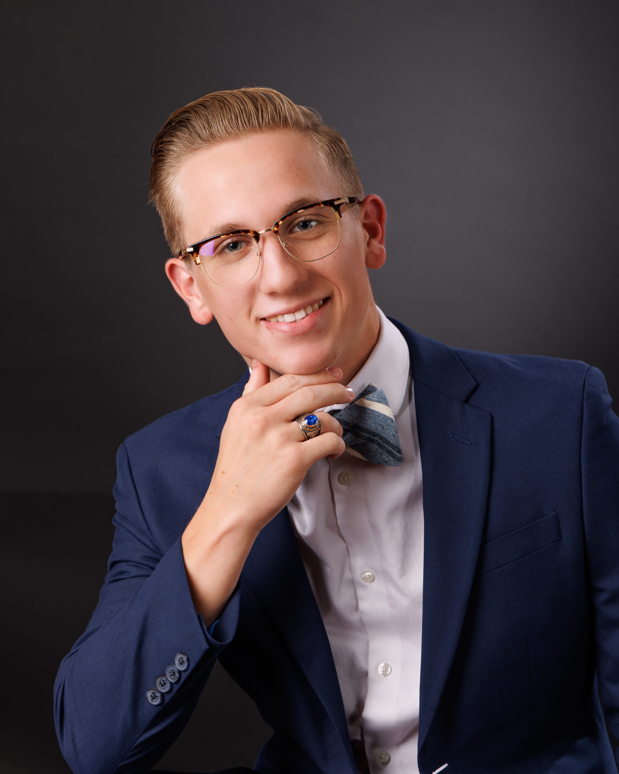 Plymouth senior photo session student wearing graduation gown holding '2025' cutout