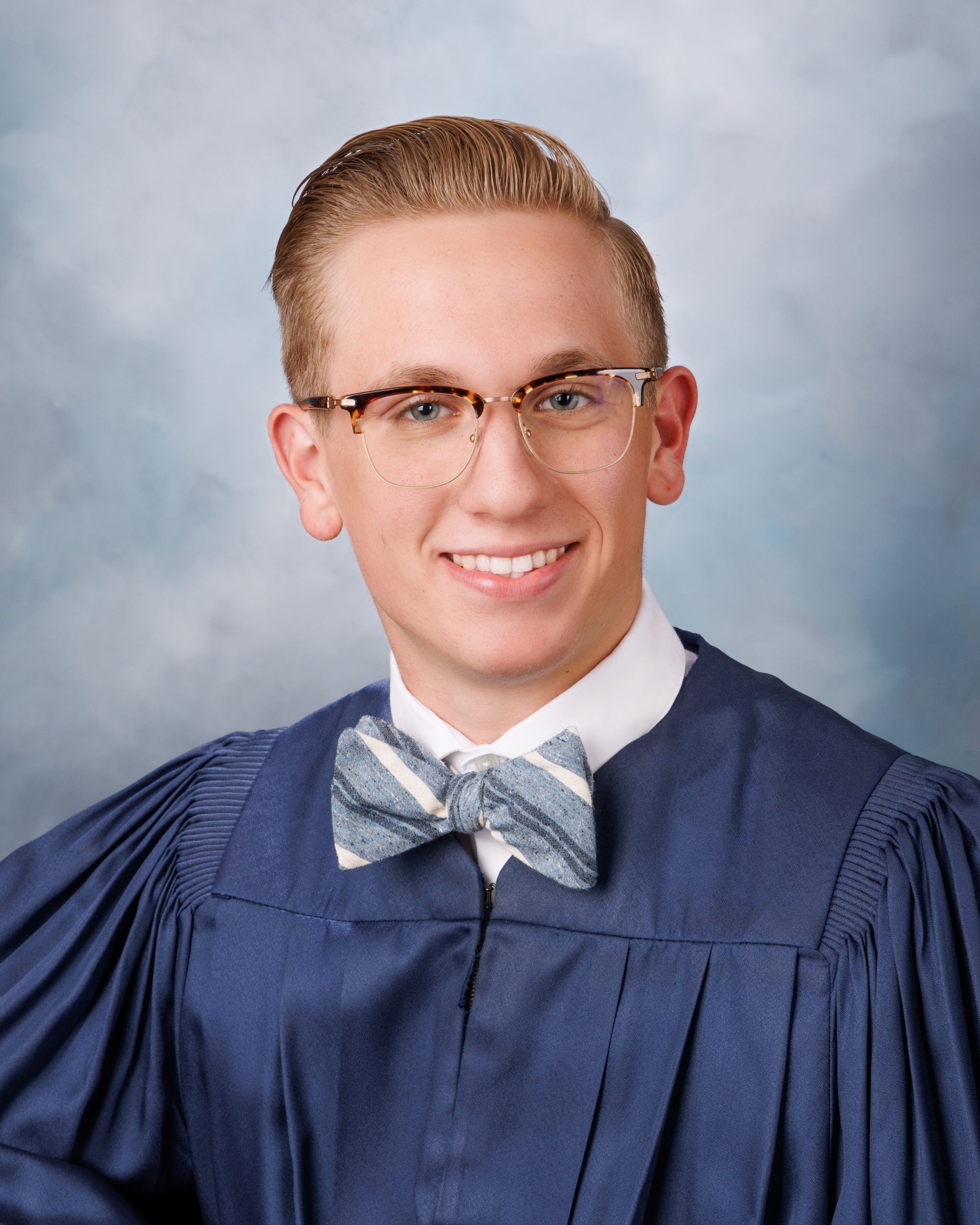 Plymouth senior photo session student wearing graduation gown holding '2025' cutout
