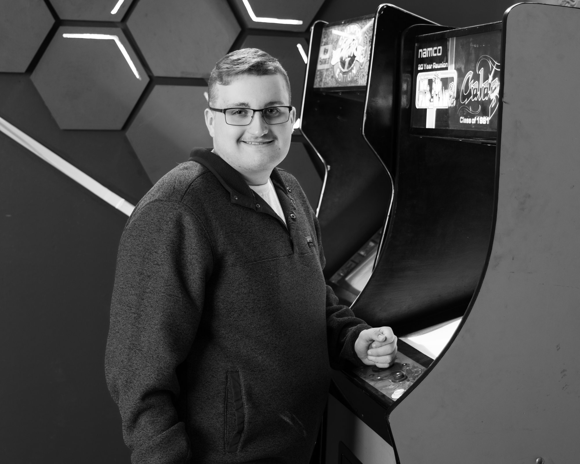 Aiden holding a 'Street Fighter' arcade cabinet in a colorful photo session