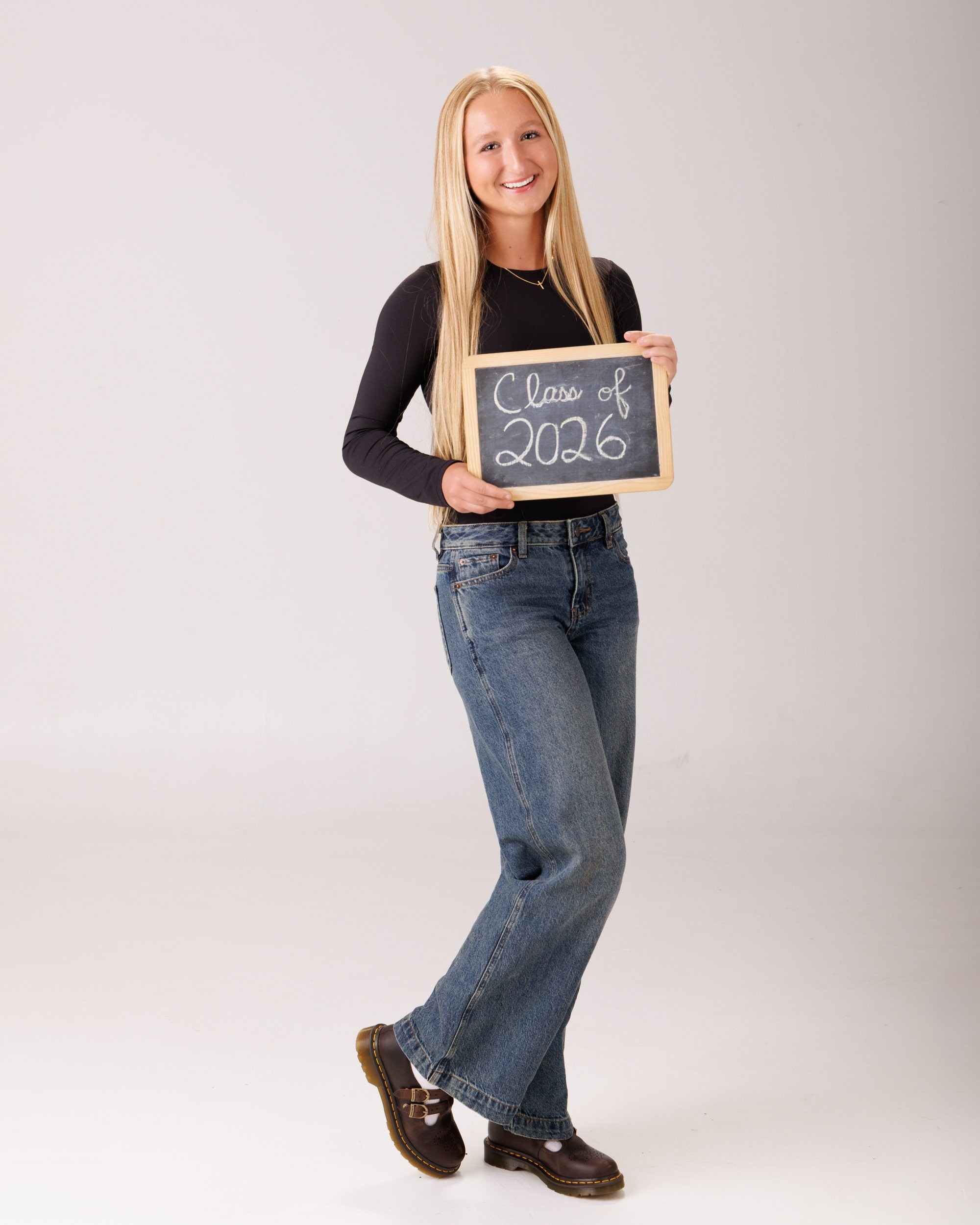 Madison sitting with football for senior photography session