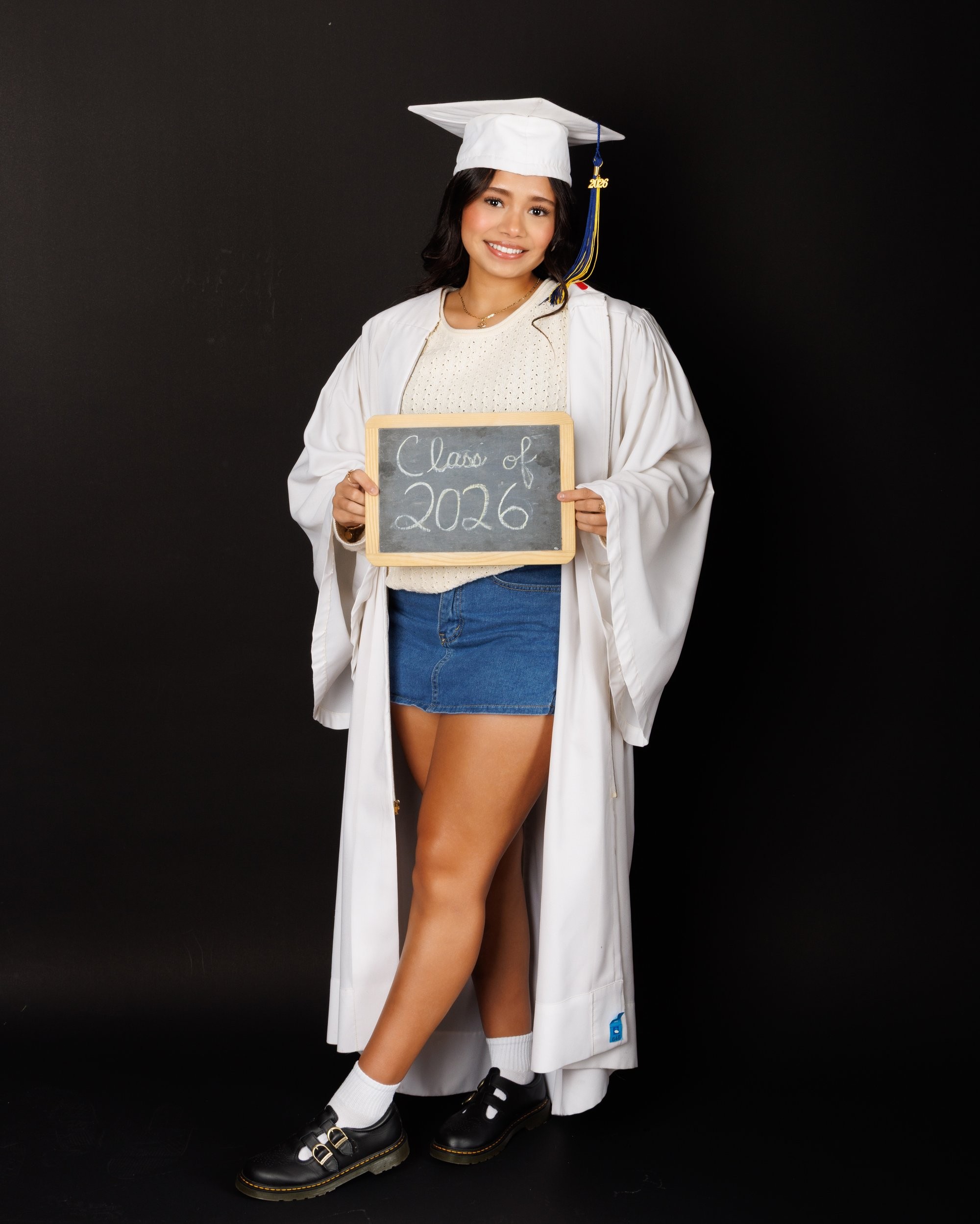 Maria in cream sweater with varsity jacket draped over shoulder