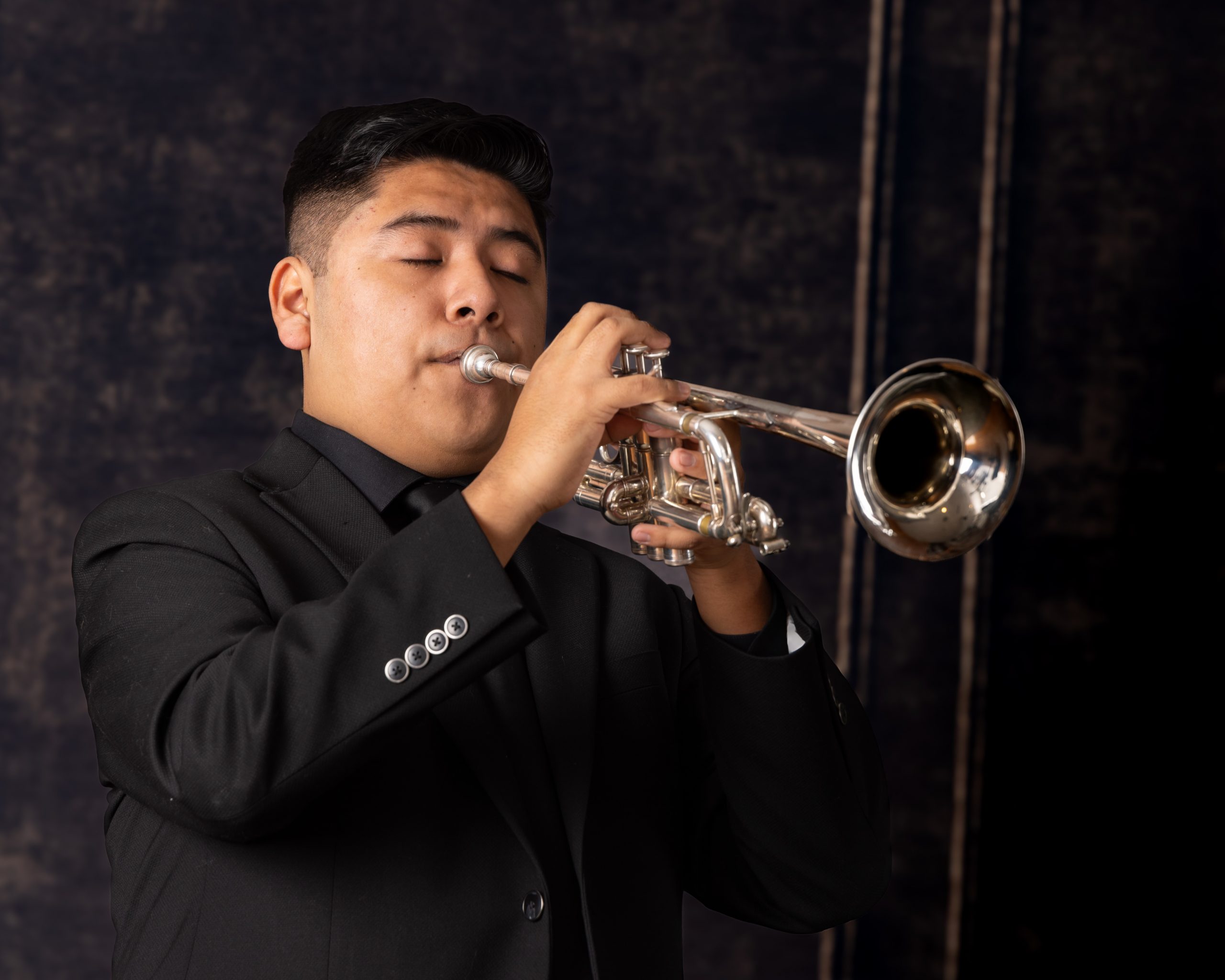 Senior musician performing on trumpet with focused expression
