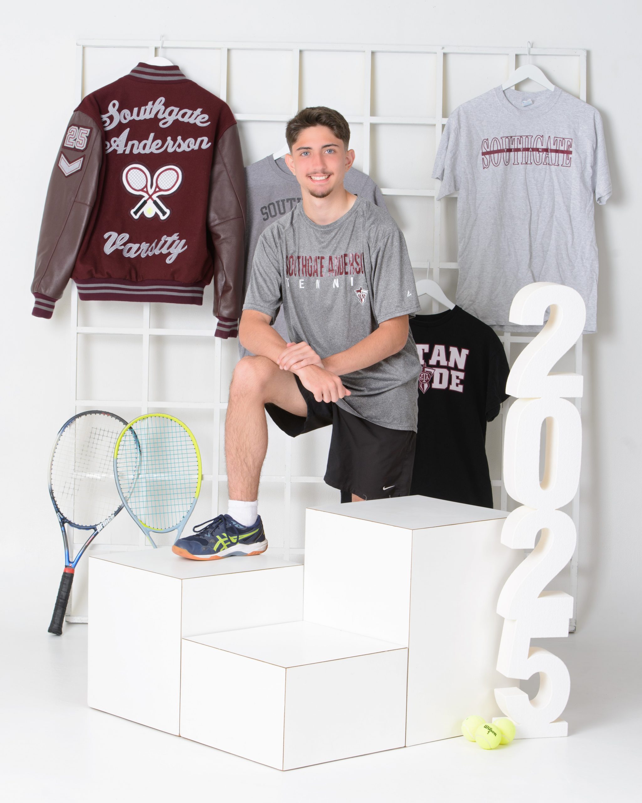 Sean posing with tennis equipment in Southgate Anderson sports attire