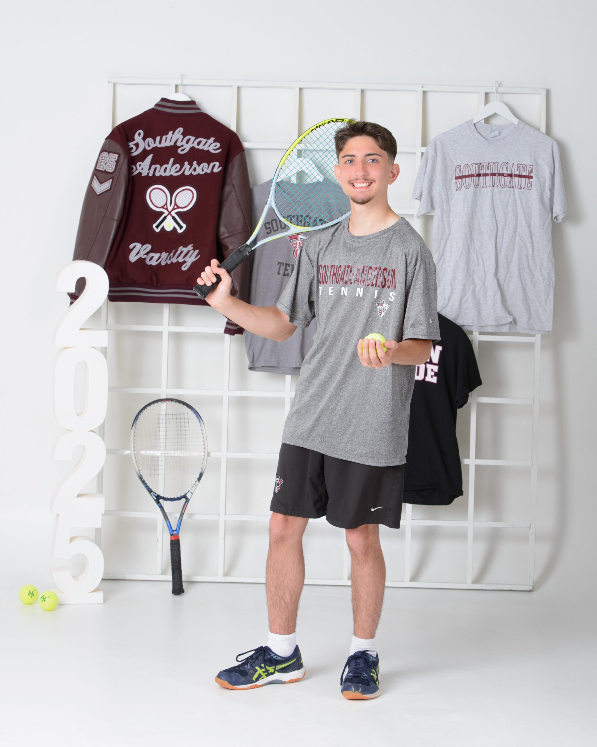 Sean posing with tennis equipment in Southgate Anderson sports attire