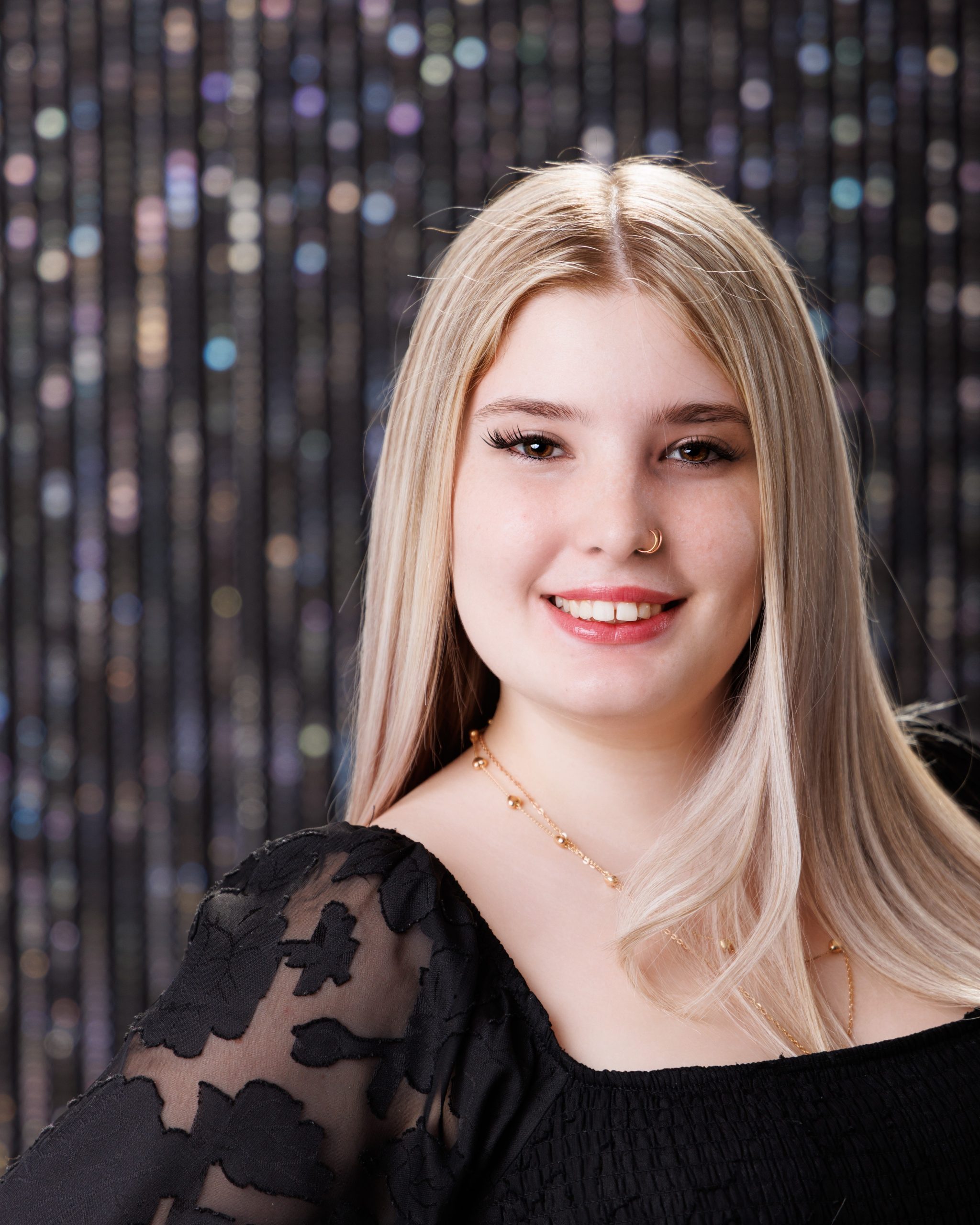 Alysha holding blue graduation cap and gown during senior photography session