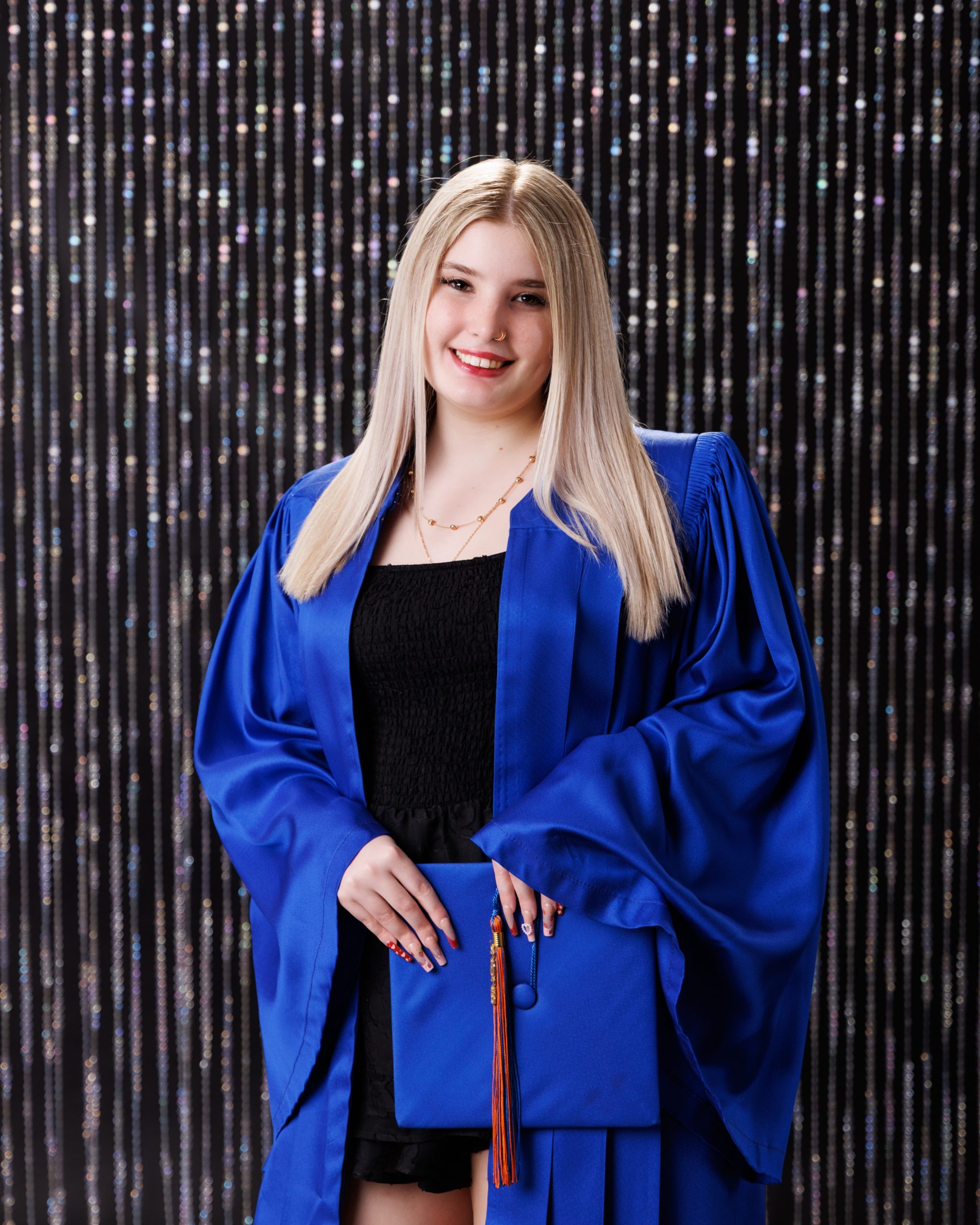 Alysha holding blue graduation cap and gown during senior photography session