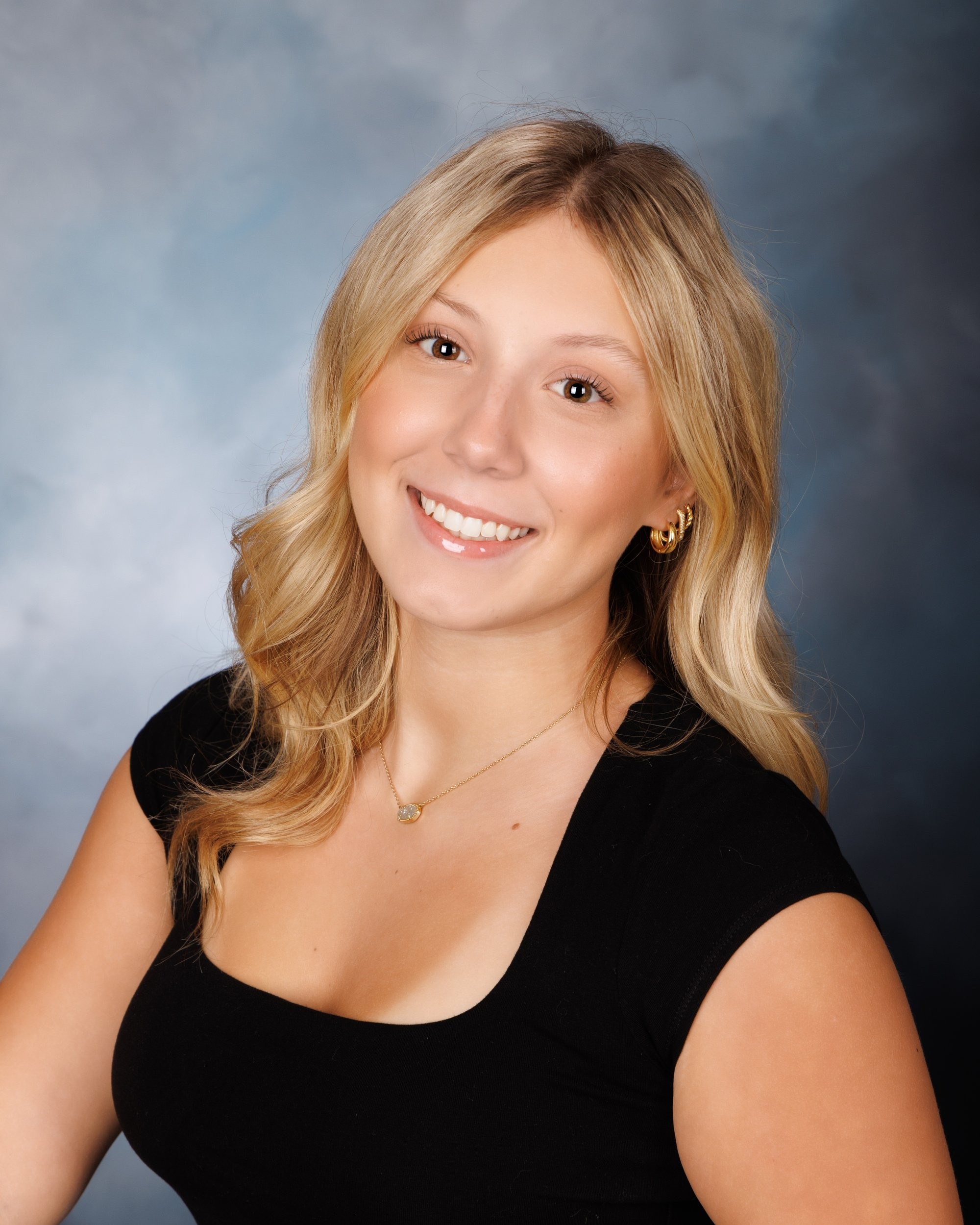 Trenton senior photography session with Alyssa smiling warmly, wearing a black top and a small pendant necklace.