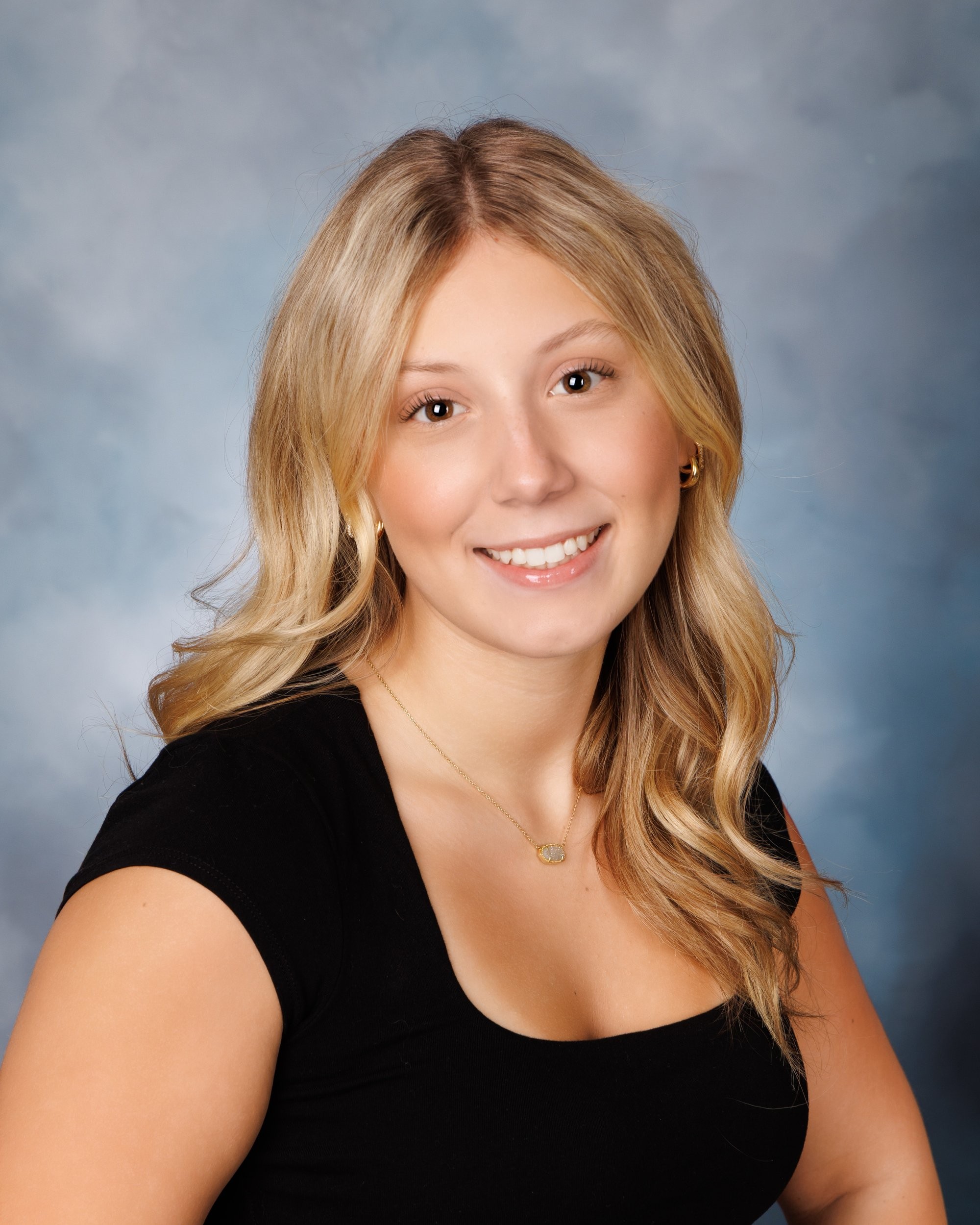 Trenton senior photography session with Alyssa smiling warmly, wearing a black top and a small pendant necklace.