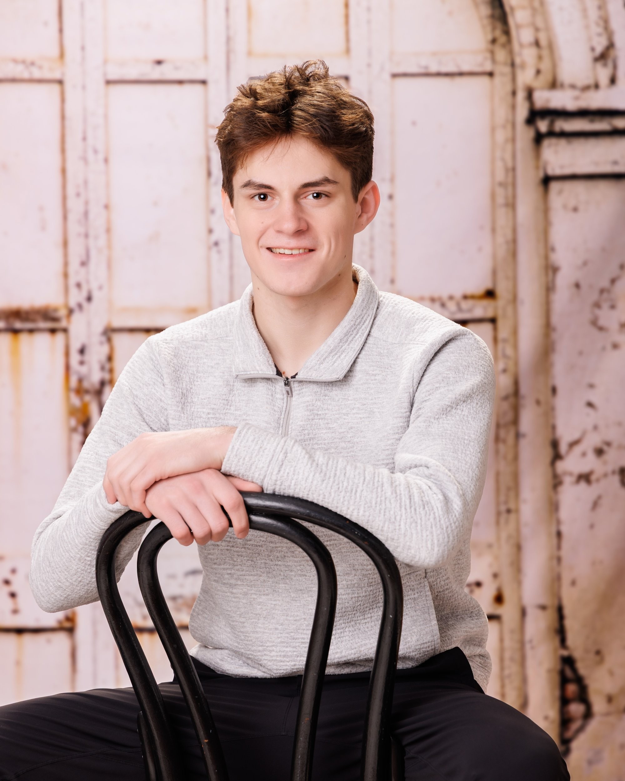 2026 milestone senior photo with the subject posed against a rustic background and large '2026' numerals