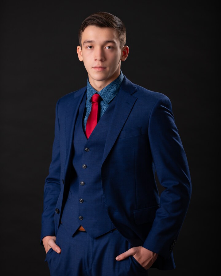 Trenton senior male model wearing blue suit and red tie for formal portrait session