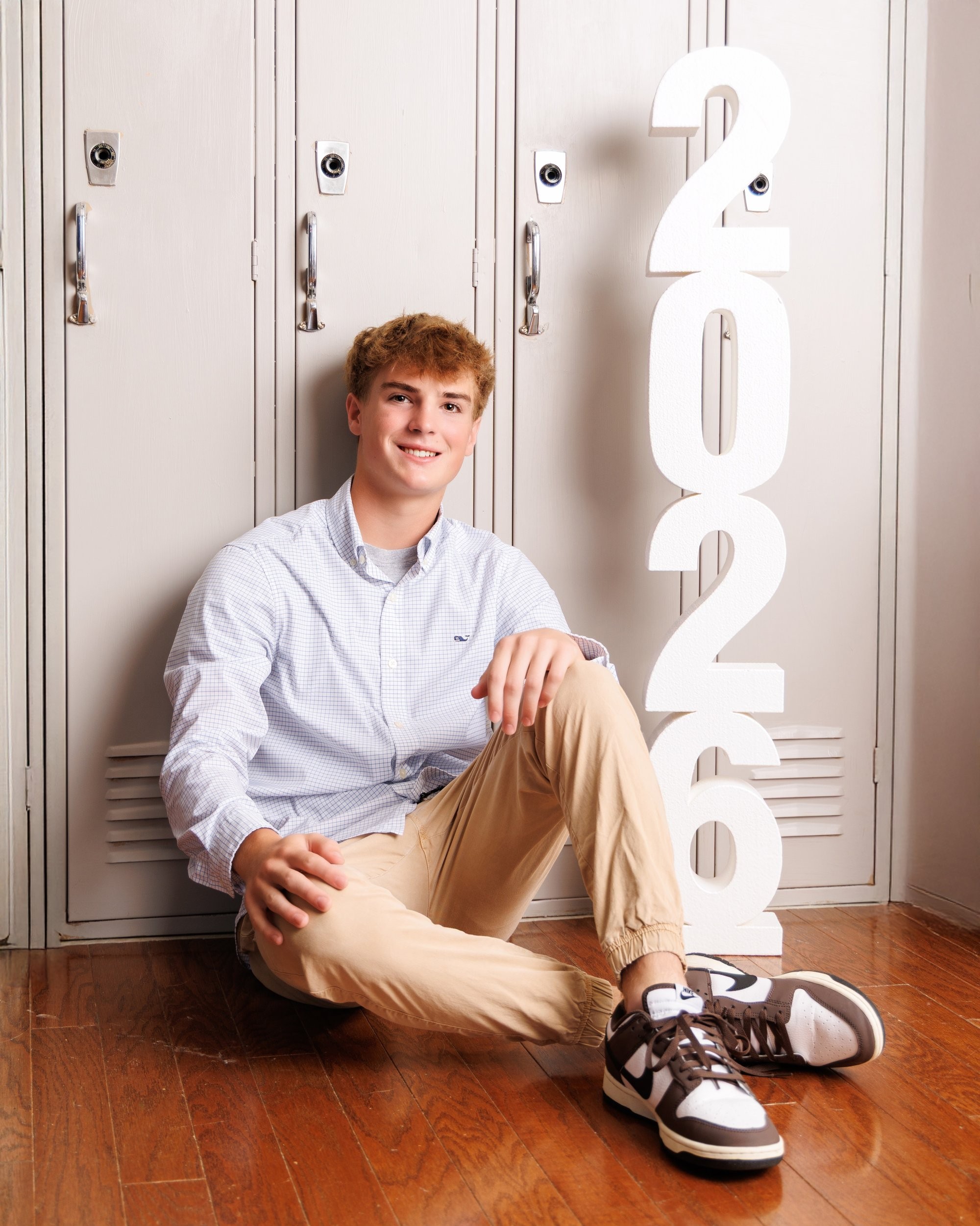 Jaxon juggling a tennis ball in a light blue checkered shirt, Trenton senior portraits