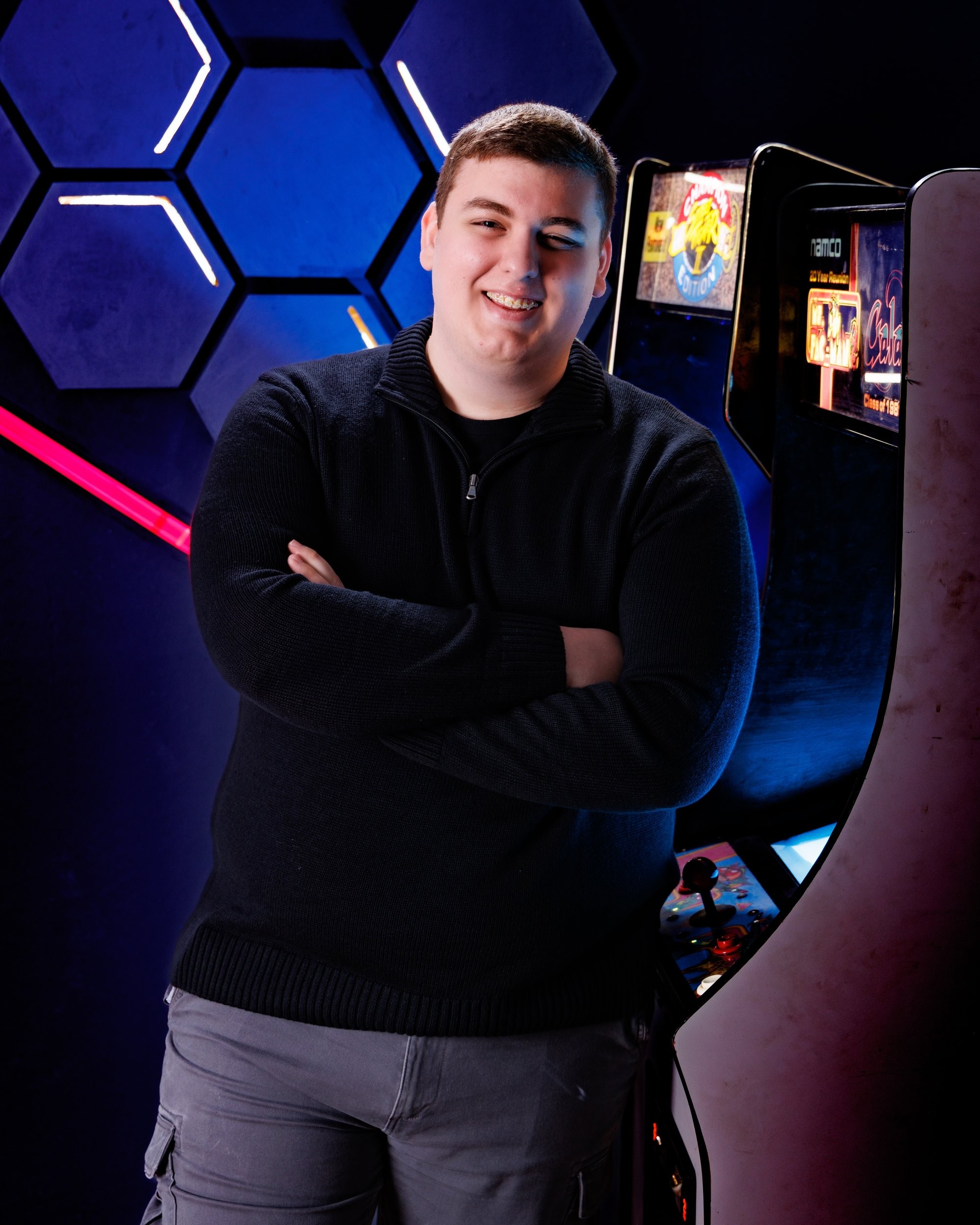 Matthew holding a game controller in a modern neon-lit studio environment